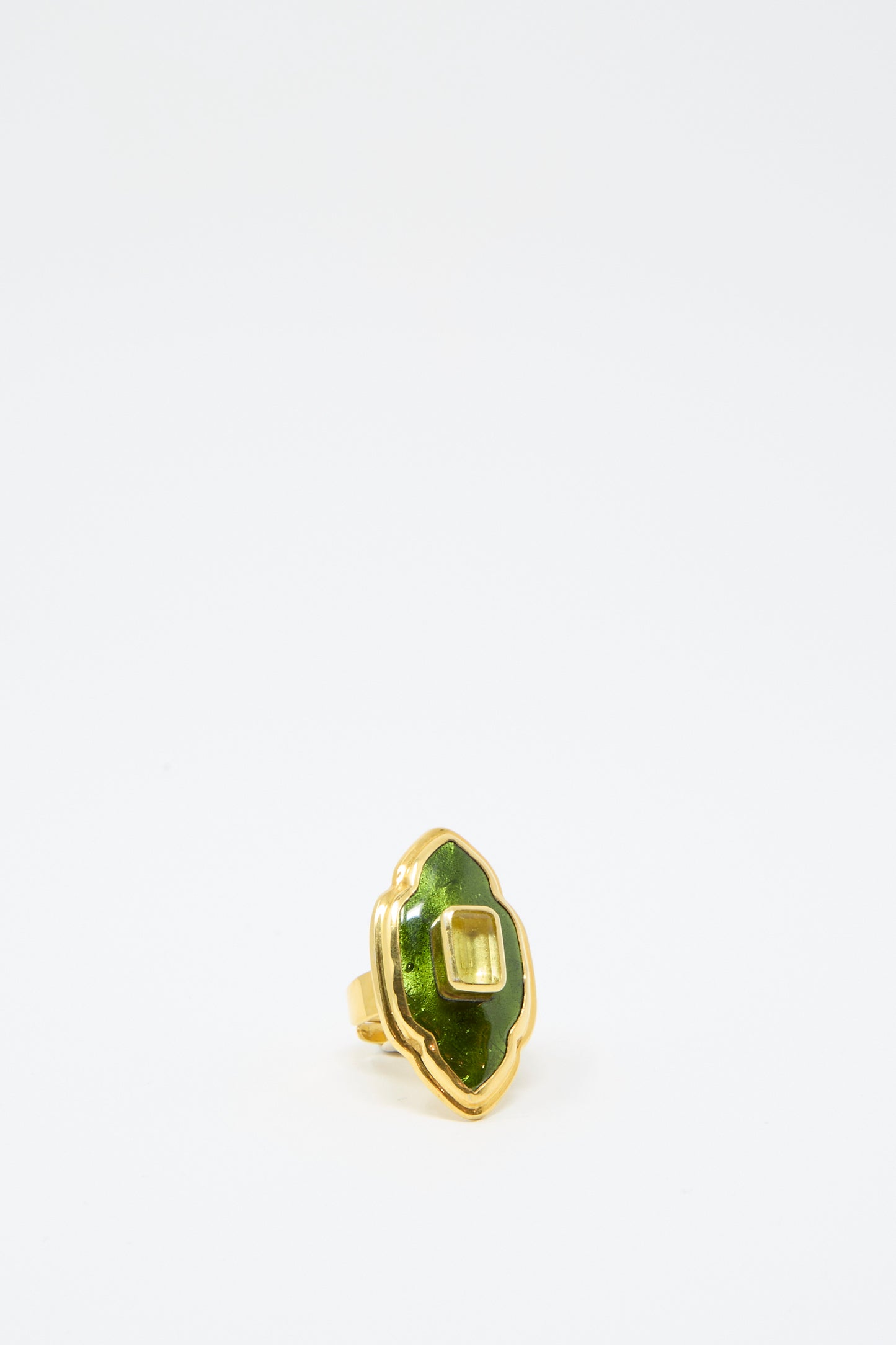 The Ring in Green and Gold from Sofio Gongli features a green gemstone set in a scalloped design on a white background.