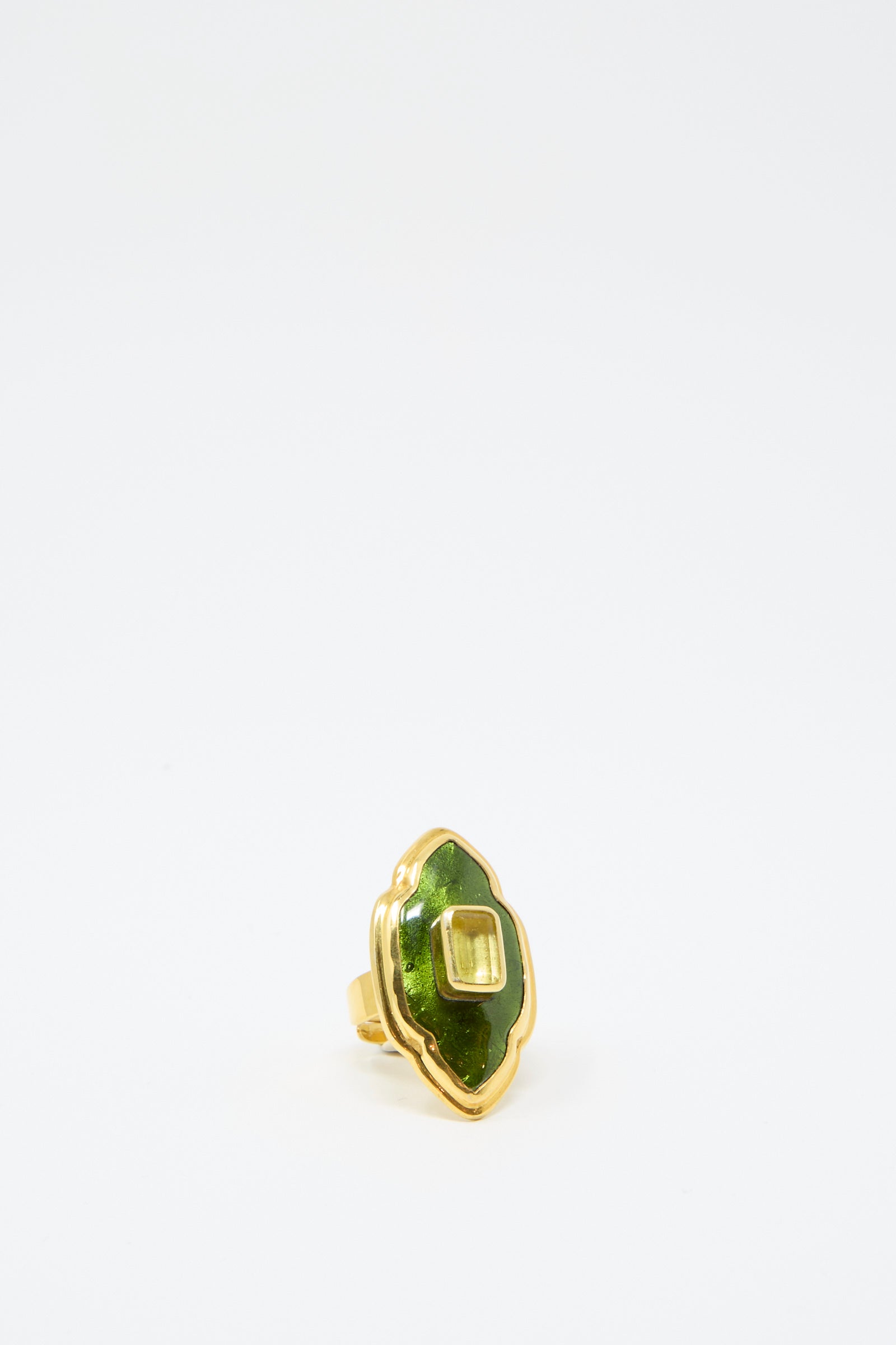 The Ring in Green and Gold from Sofio Gongli features a green gemstone set in a scalloped design on a white background.