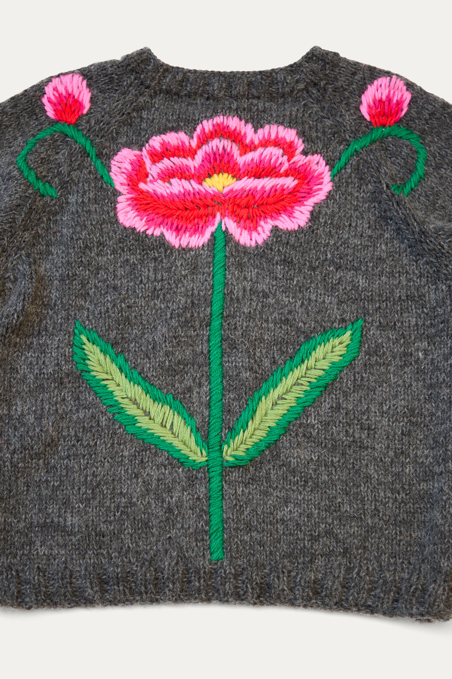 The Sofio Gongli charcoal sweater, made from a cozy mohair wool blend, features a large embroidered red and pink flower with green leaves on the back.