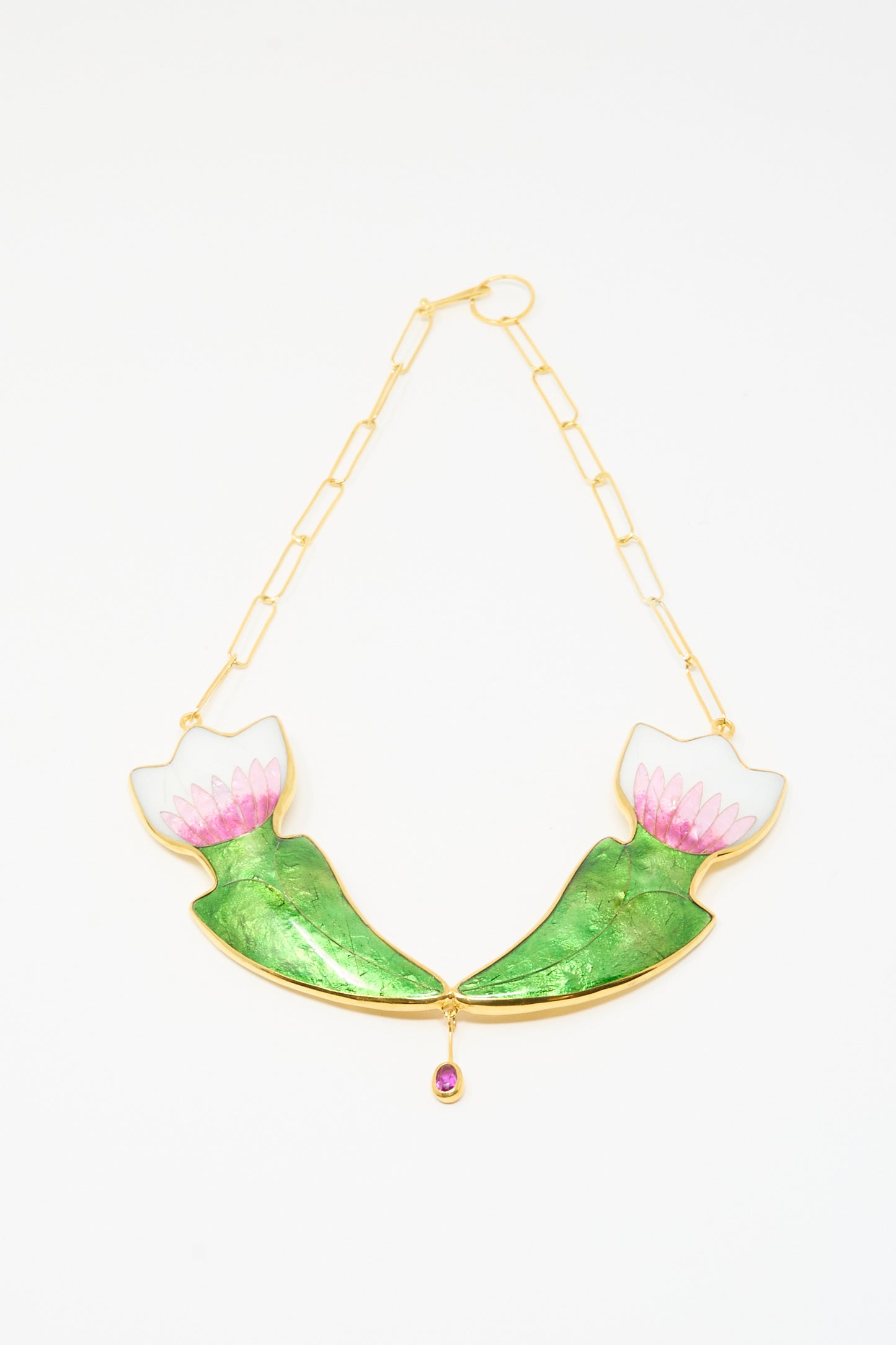 The Sofio Gongli Flower Necklace features two green and pink lotus flowers facing each other with a pink gemstone at the center. 