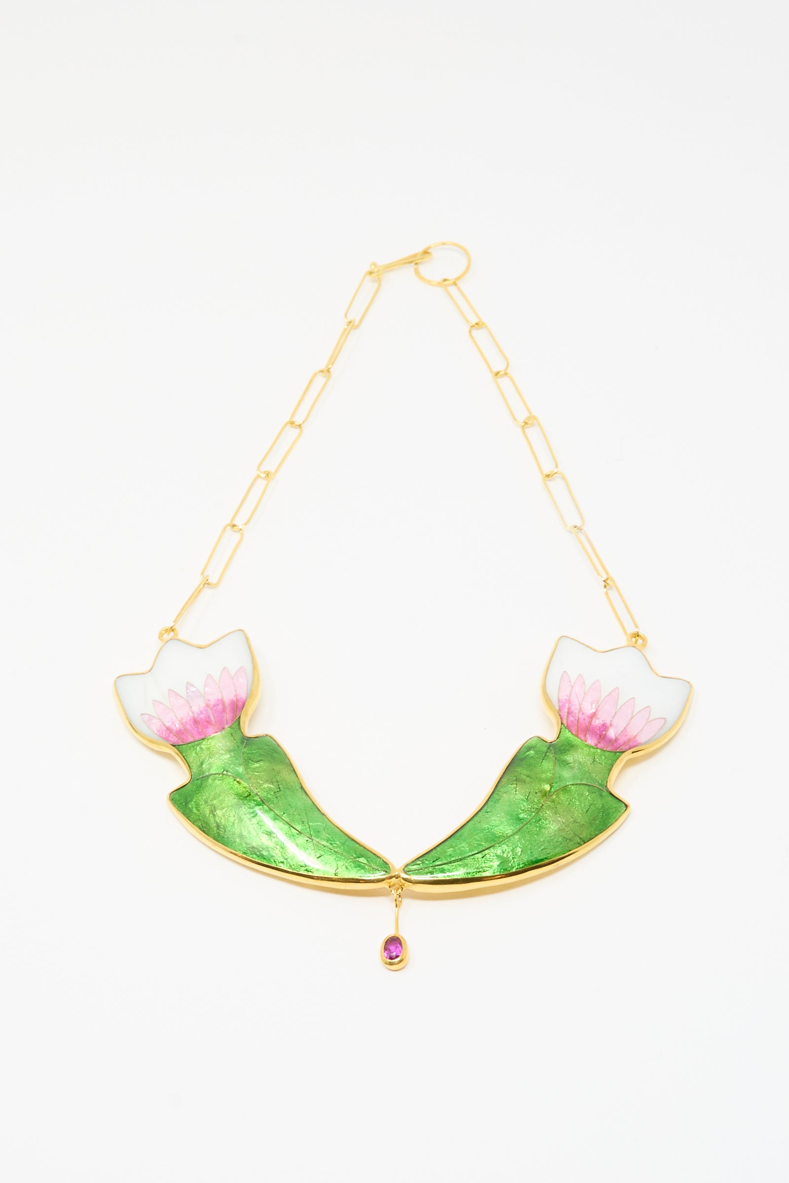 The Sofio Gongli Flower Necklace features two green and pink lotus flowers facing each other with a pink gemstone at the center. 
