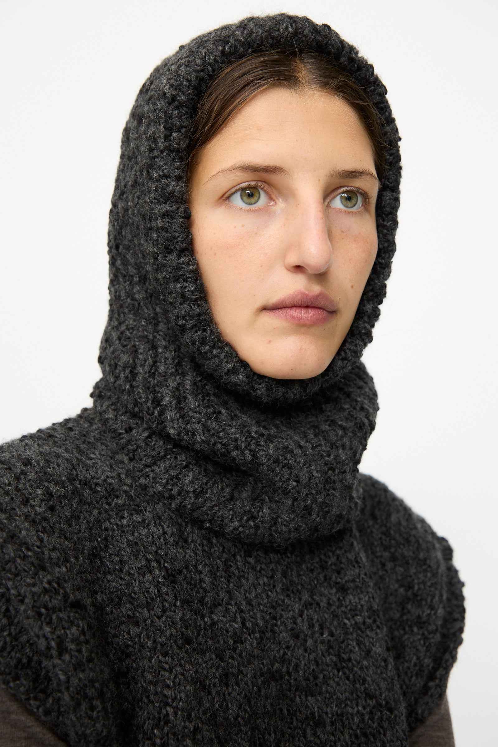 A person with light eyes and brown hair wears the SONO Alpaca and Wool Bruna Balaclava in Charcoal, looking slightly off-camera against a plain background.