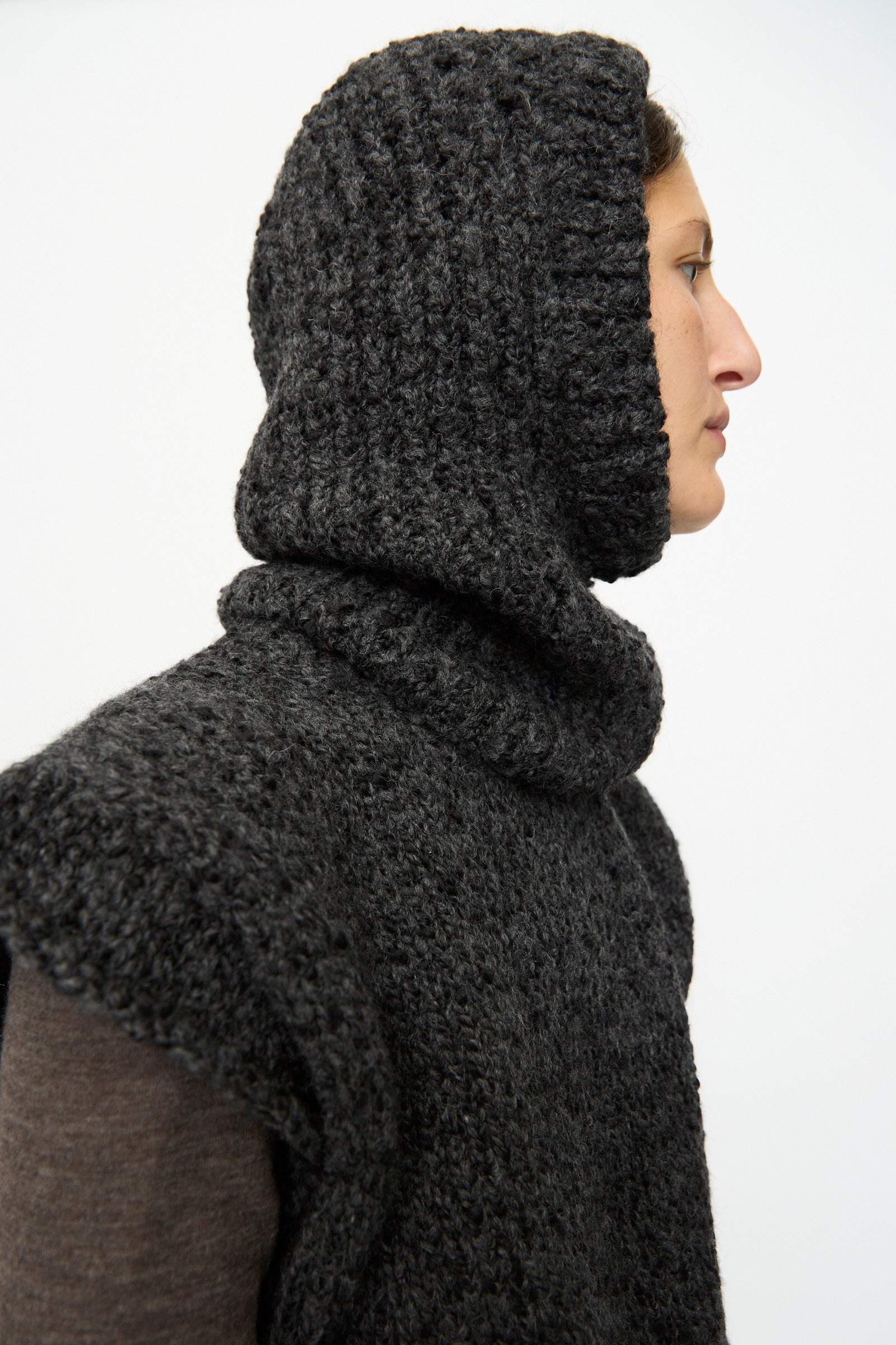 A person in profile wears the SONO Alpaca and Wool Bruna Balaclava in Charcoal over a long-sleeved shirt, set against a plain light background.