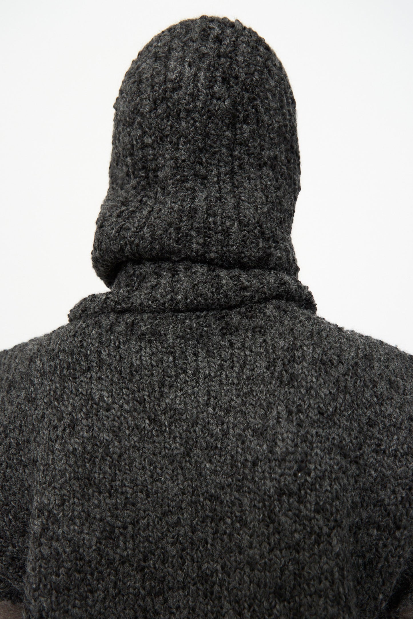 A person wearing the SONO Alpaca and Wool Bruna Balaclava in Charcoal is seen from behind against a plain white background.