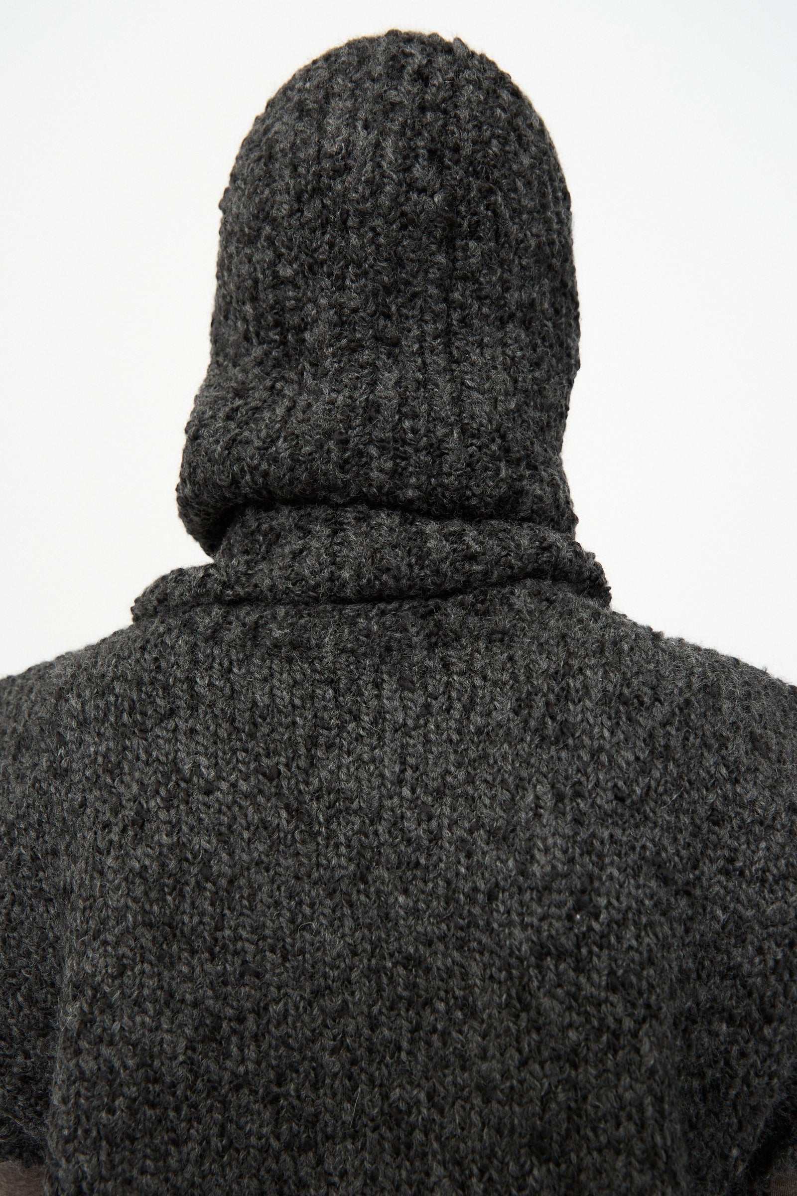 A person wearing the SONO Alpaca and Wool Bruna Balaclava in Charcoal is seen from behind against a plain white background.