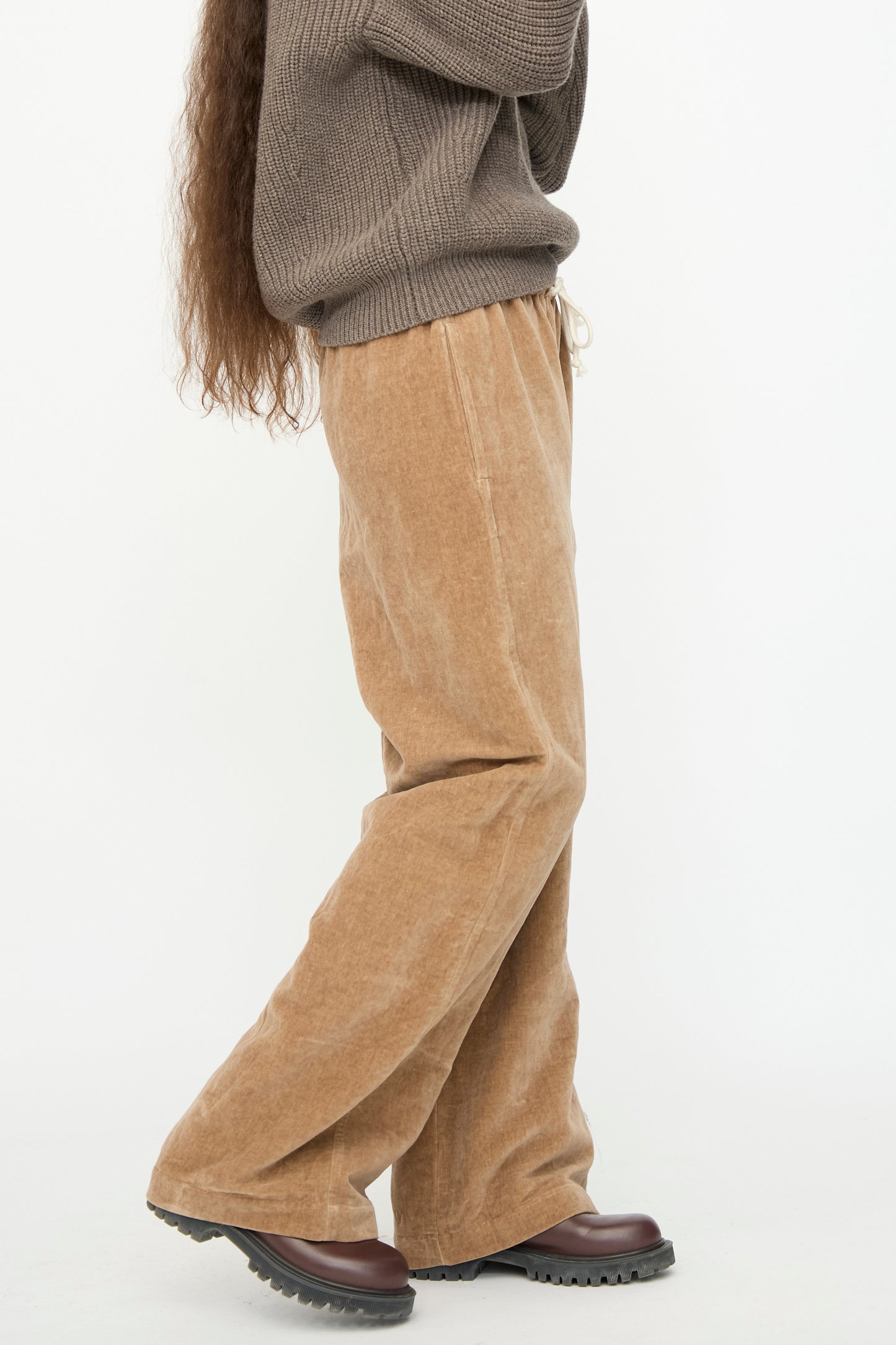 A person is standing sideways against a plain white background, wearing the SONO Johnny Jogger in Desert Rose paired with dark brown shoes.
