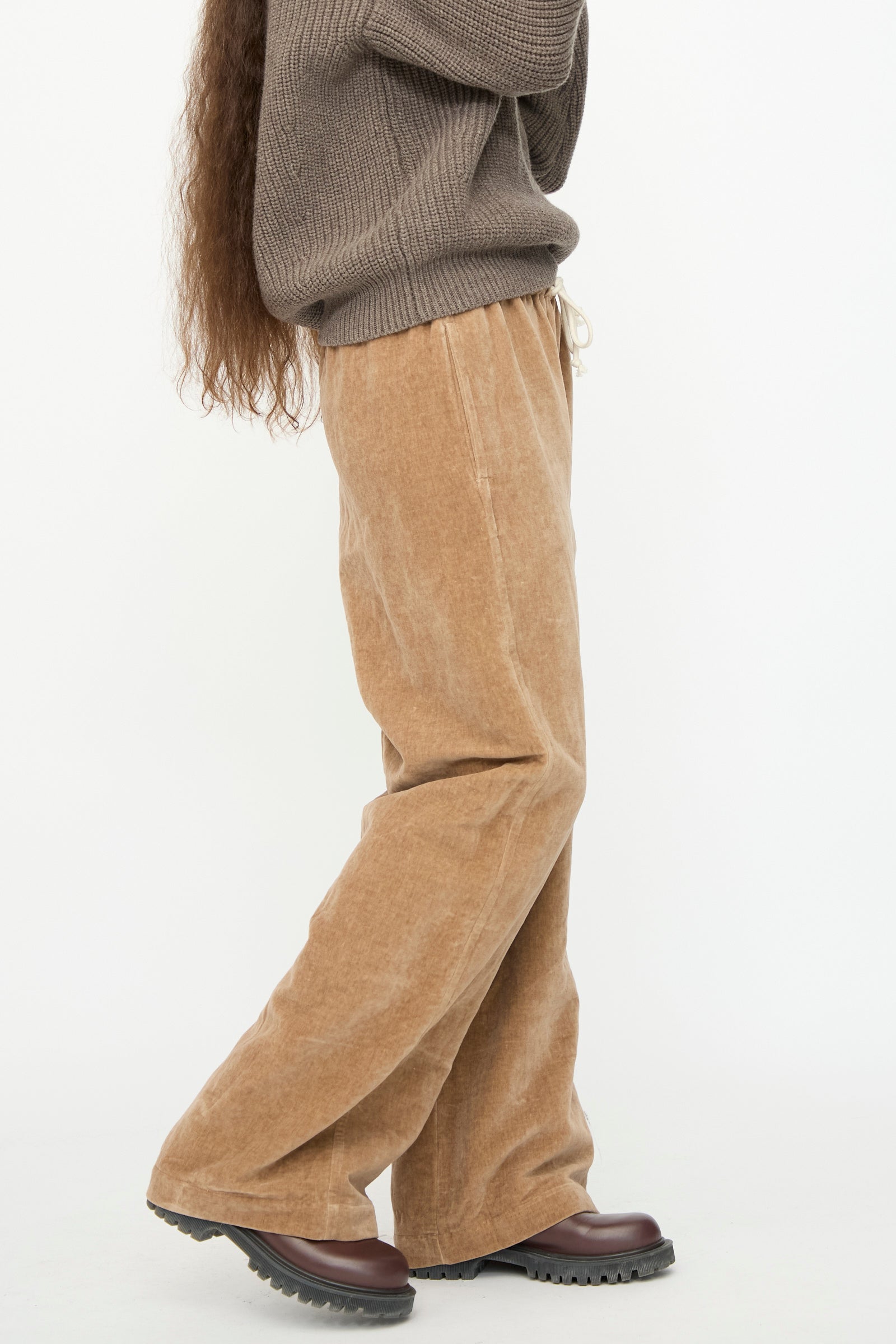 A person is standing sideways against a plain white background, wearing the SONO Johnny Jogger in Desert Rose paired with dark brown shoes.
