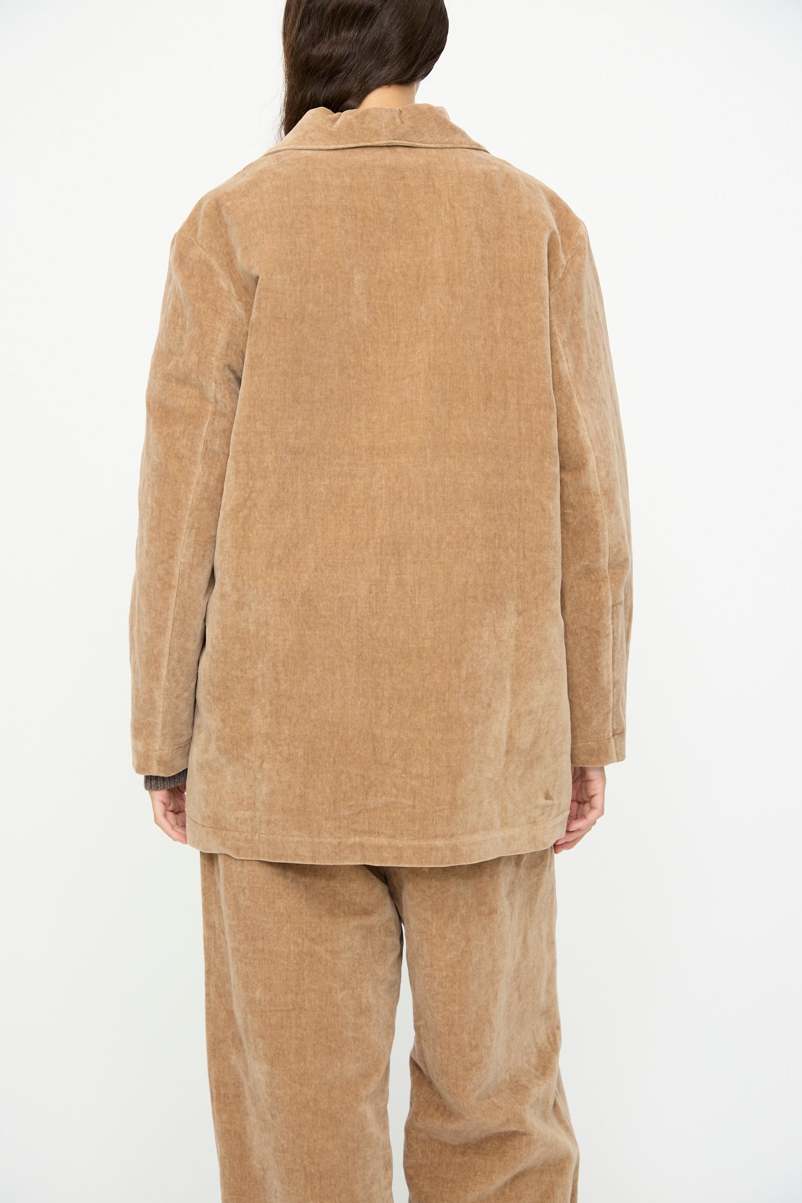 A person wearing the SONO Yoyogi Jacket in Desert Rose stands with their back to the camera against a plain white background.