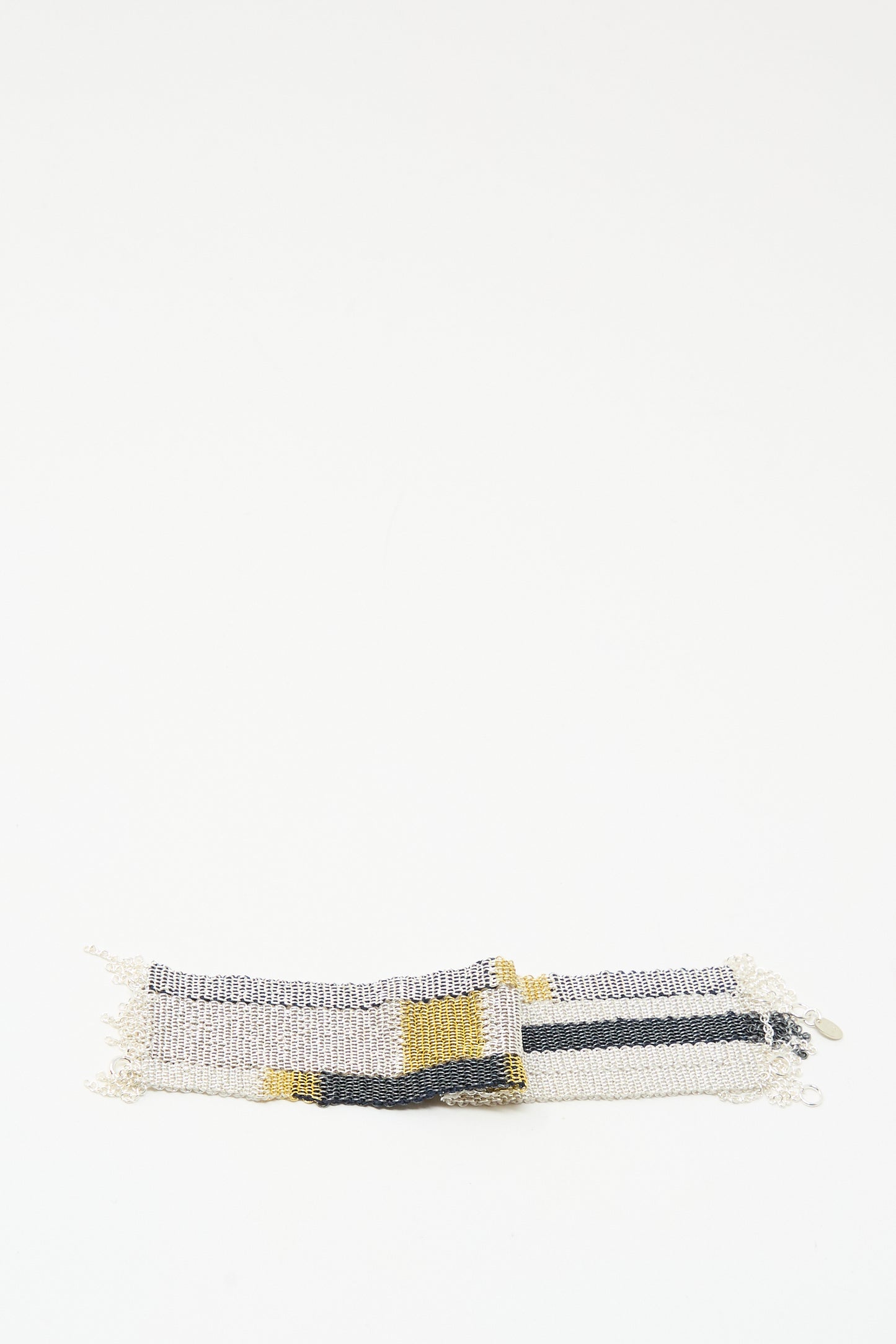 The Stephanie Schneider Silver Oxidized, Gold Plated and Silk Woven Bracelet with silver, black, and yellow stripes is shown on a plain white background.