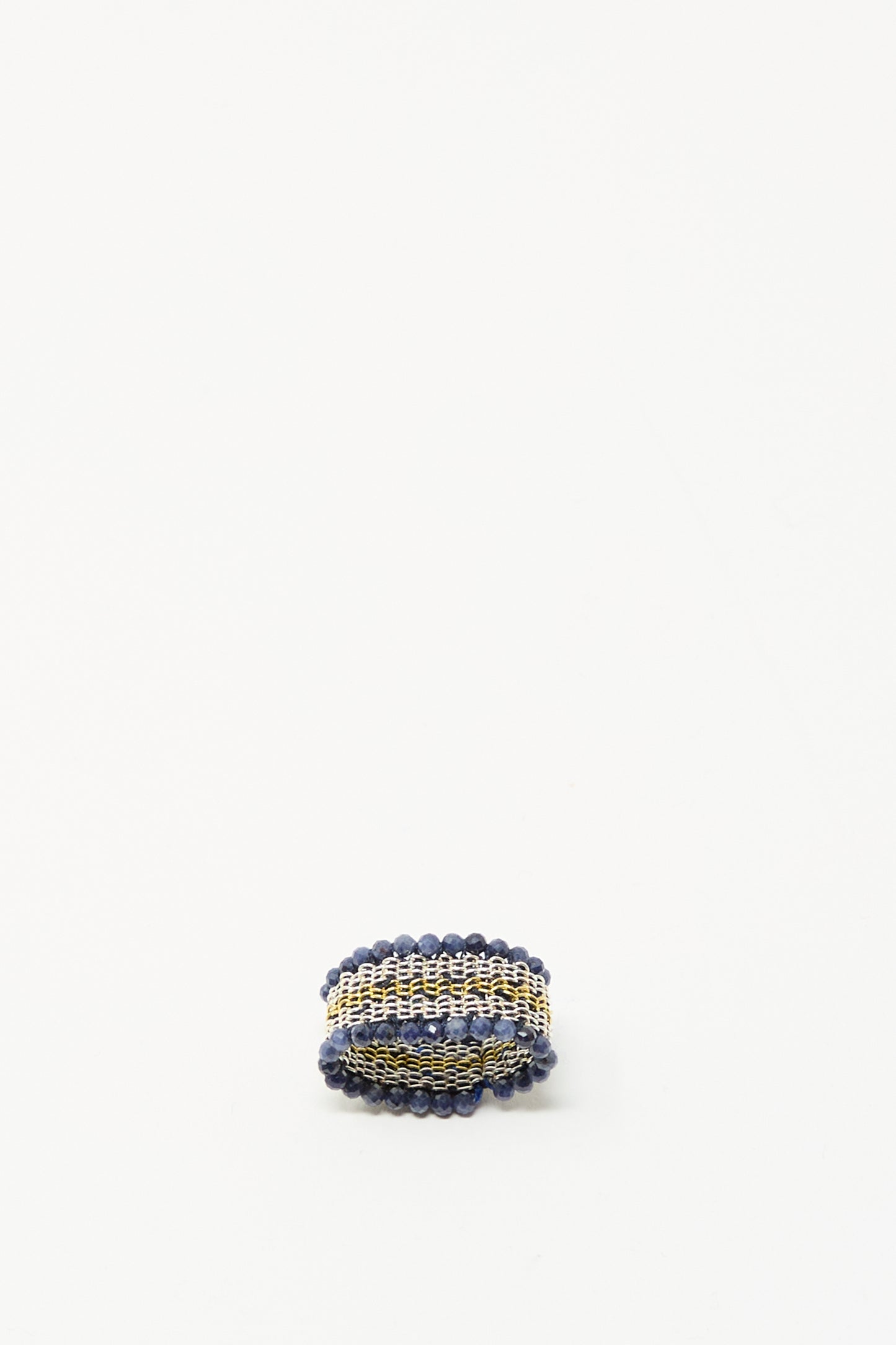 The Stephanie Schneider Silver, Gold Plated, and Silk Woven Ring with Blue Sapphires is displayed on a plain white background.