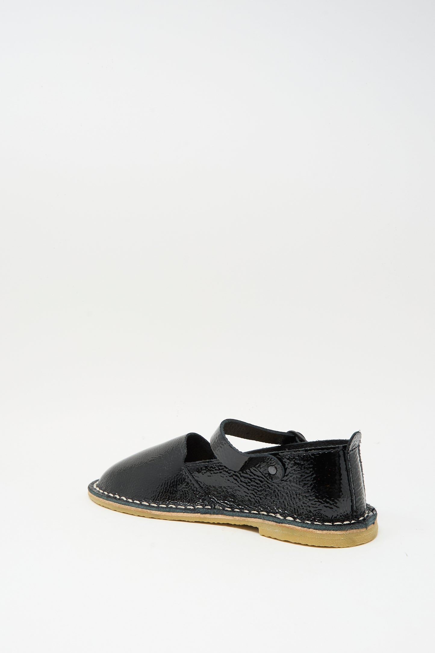 The Steve Mono Mary Jane in Glossy Black features a closed toe, ankle strap, and tan recycled rubber sole, shown individually against a plain white background.