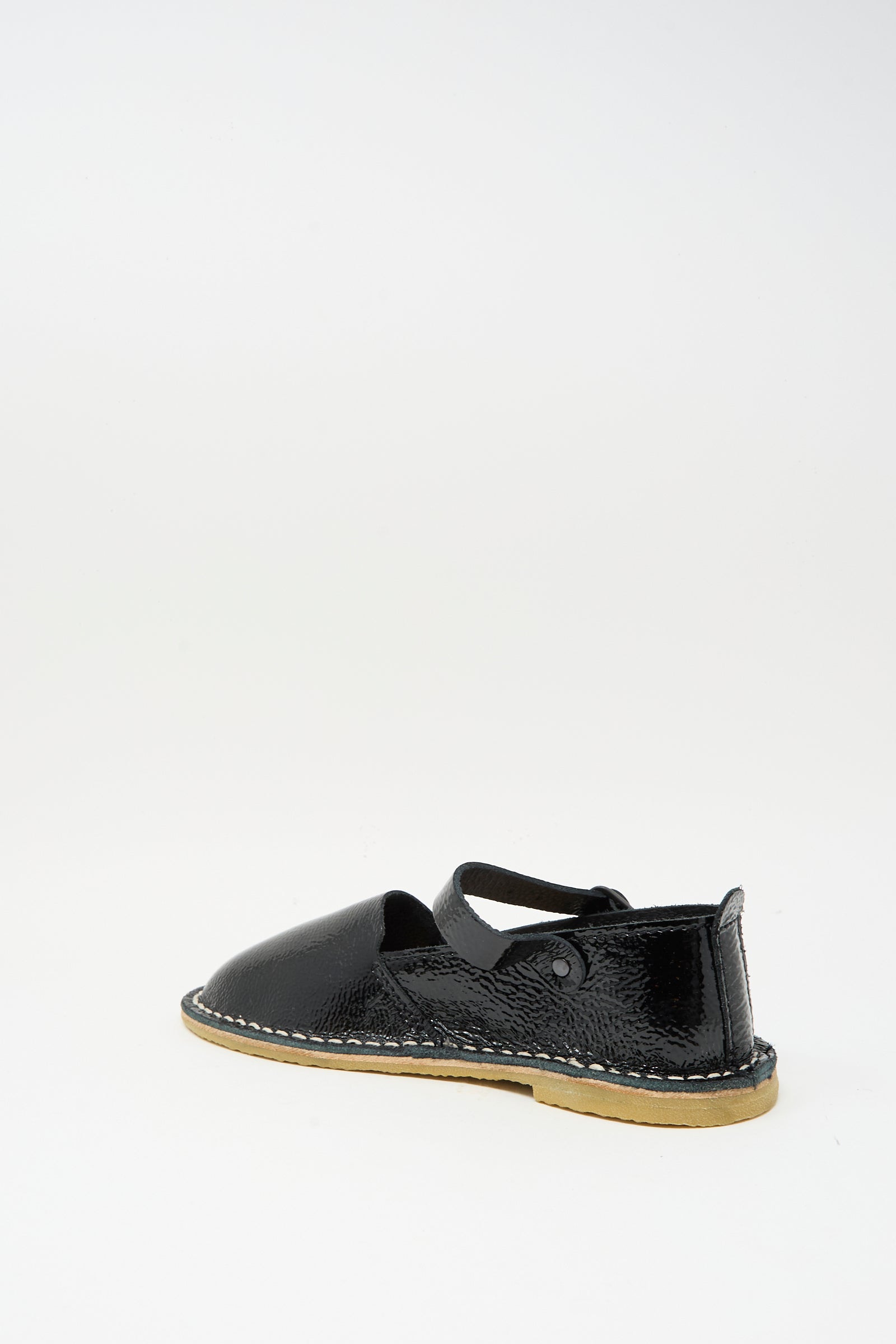 The Steve Mono Mary Jane in Glossy Black features a closed toe, ankle strap, and tan recycled rubber sole, shown individually against a plain white background.