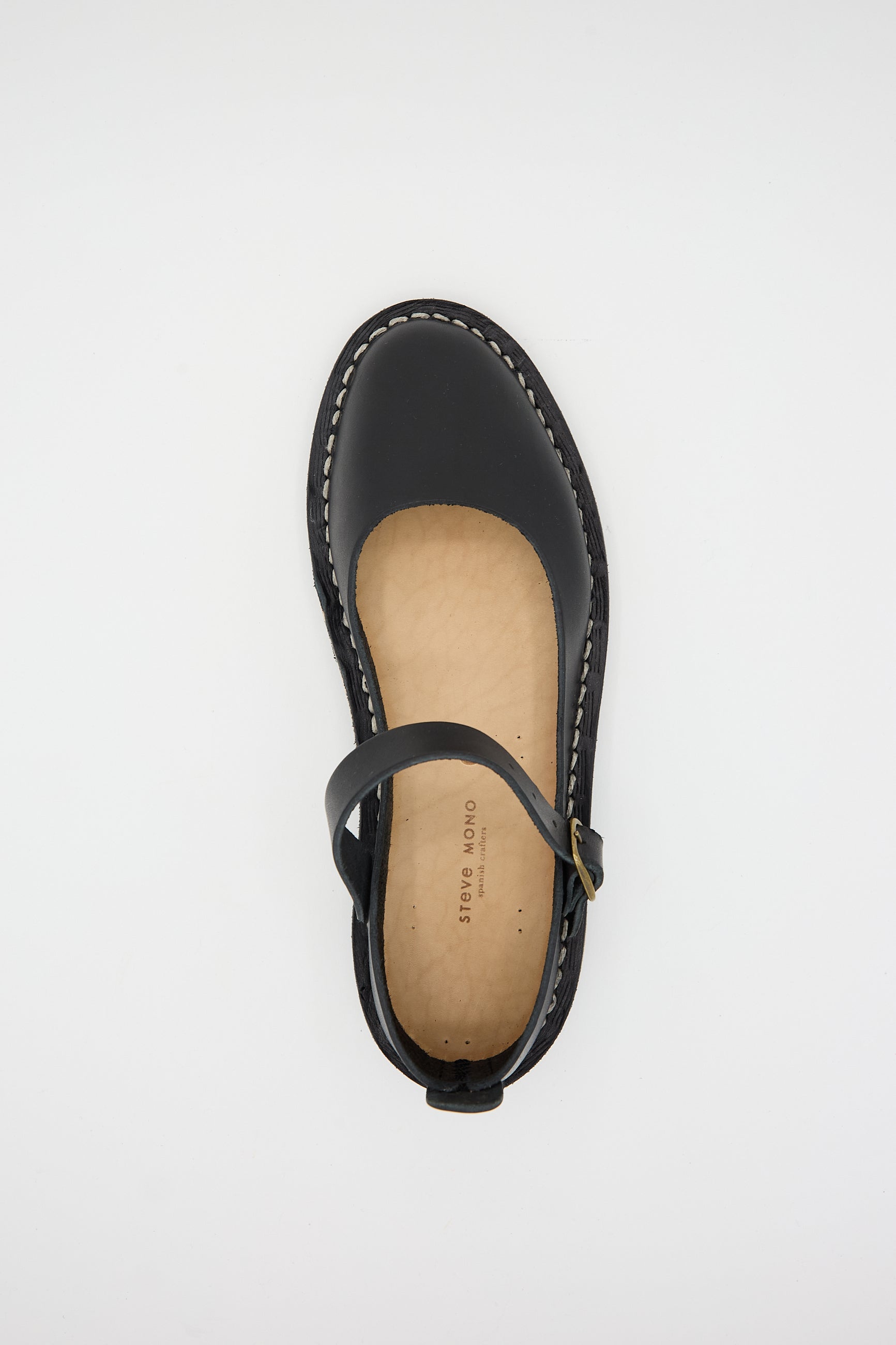 Single black artisanal Mary Jane flat shoe with a rounded toe and a buckle strap, expertly crafted from sustainably made, vegetable tanned calfskin leather, displayed on a white background. This is the Vegetable Tanned Calfskin Artisanal Sandal in Black by Steve Mono.