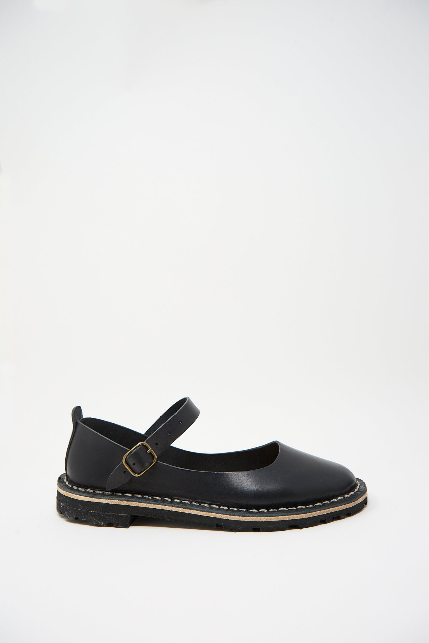 A single Vegetable Tanned Calfskin Artisanal Sandal in Black by Steve Mono crafted from vegetable tanned calfskin leather, featuring a buckle strap, visible stitching around the sole, and a black rubber outsole against a plain white background.