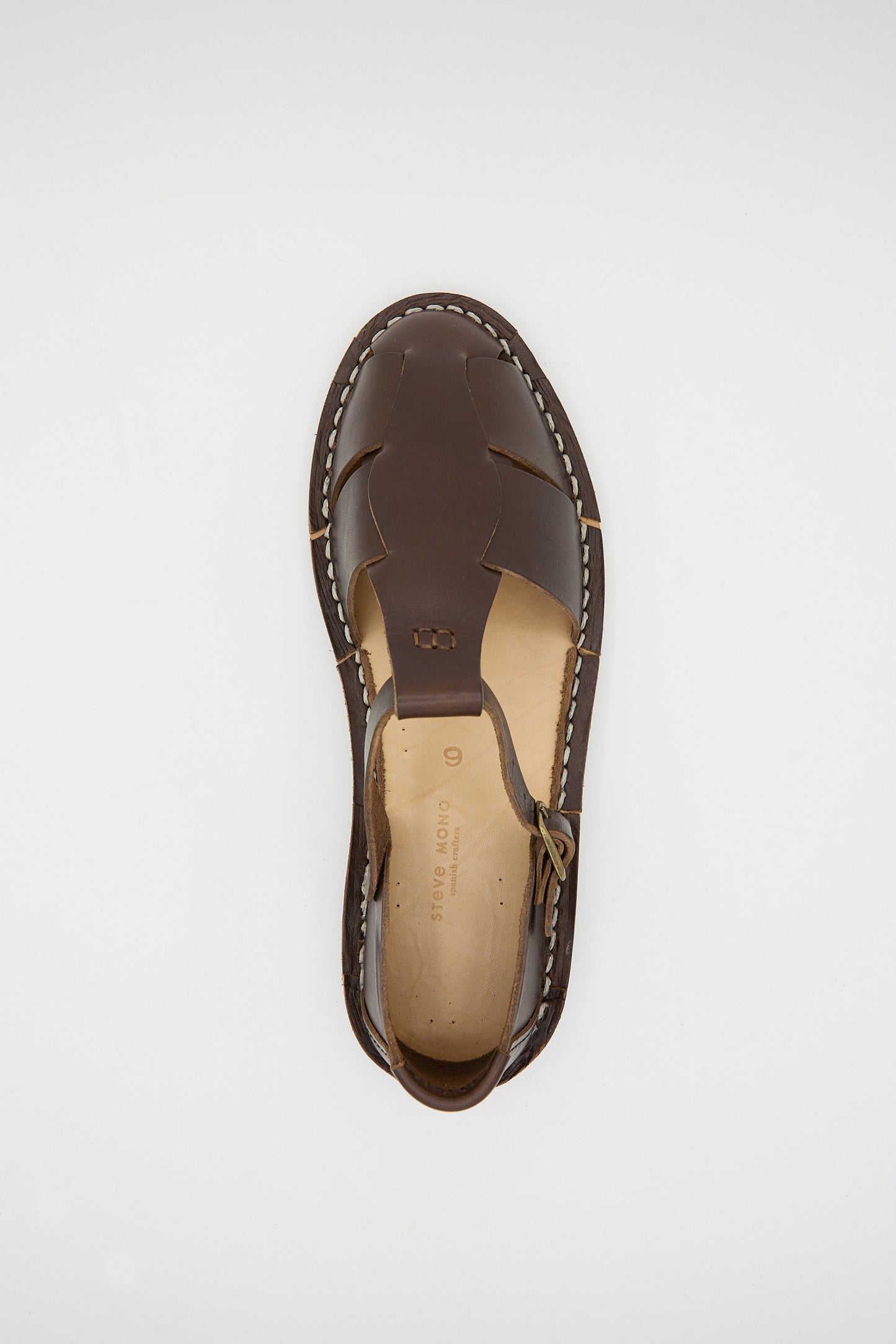 Top view of a single Vegetable Tanned Calfskin Artisanal Sandal in Coffee by Steve Mono with cutout details and white stitching, displayed against a plain white background. This sandal is sustainably made, marrying style with environmental responsibility.