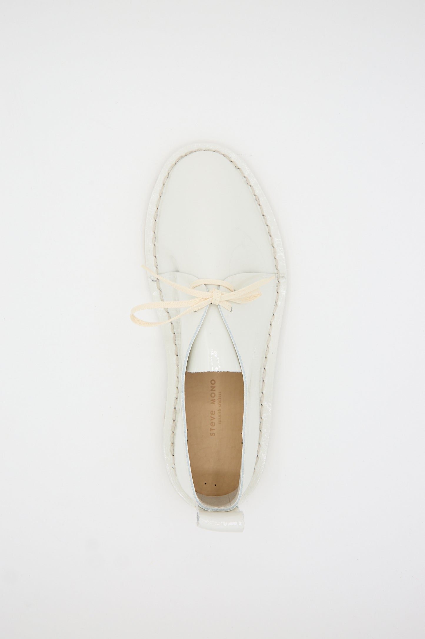 Top view of a single Steve Mono Patent Leather Derbie in White with cream laces and a tan insole against a white background, showcasing its sustainably made design.