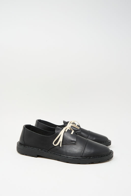 The Steve Mono Leather Oxford in Black features vegetable-tanned leather, contrasting white laces, and is crafted in Spain. Displayed on a plain white background.
