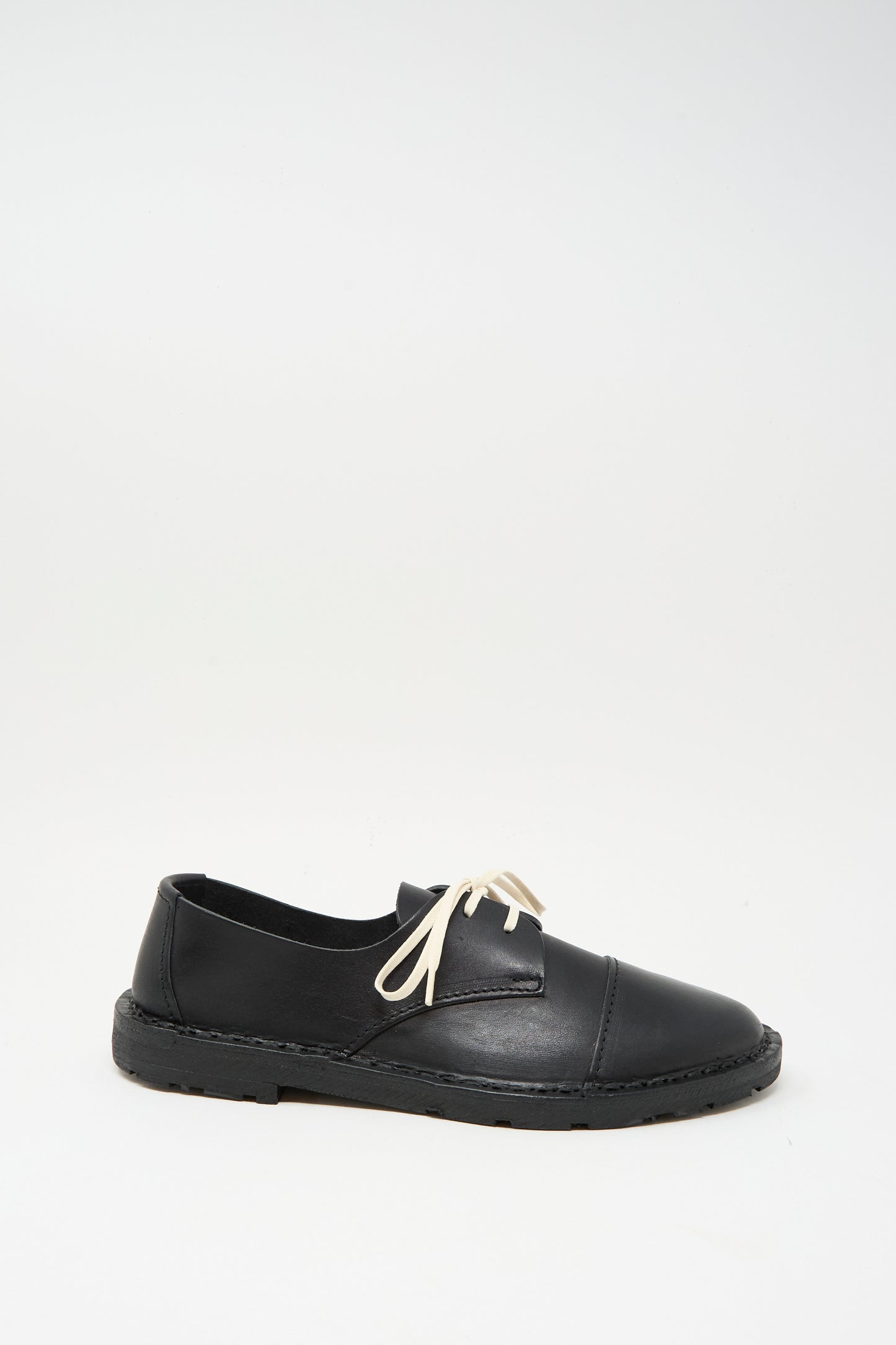The Steve Mono Leather Oxford in Black features a rounded toe, low heel, white laces, and vegetable-tanned leather, shown against a plain white background.