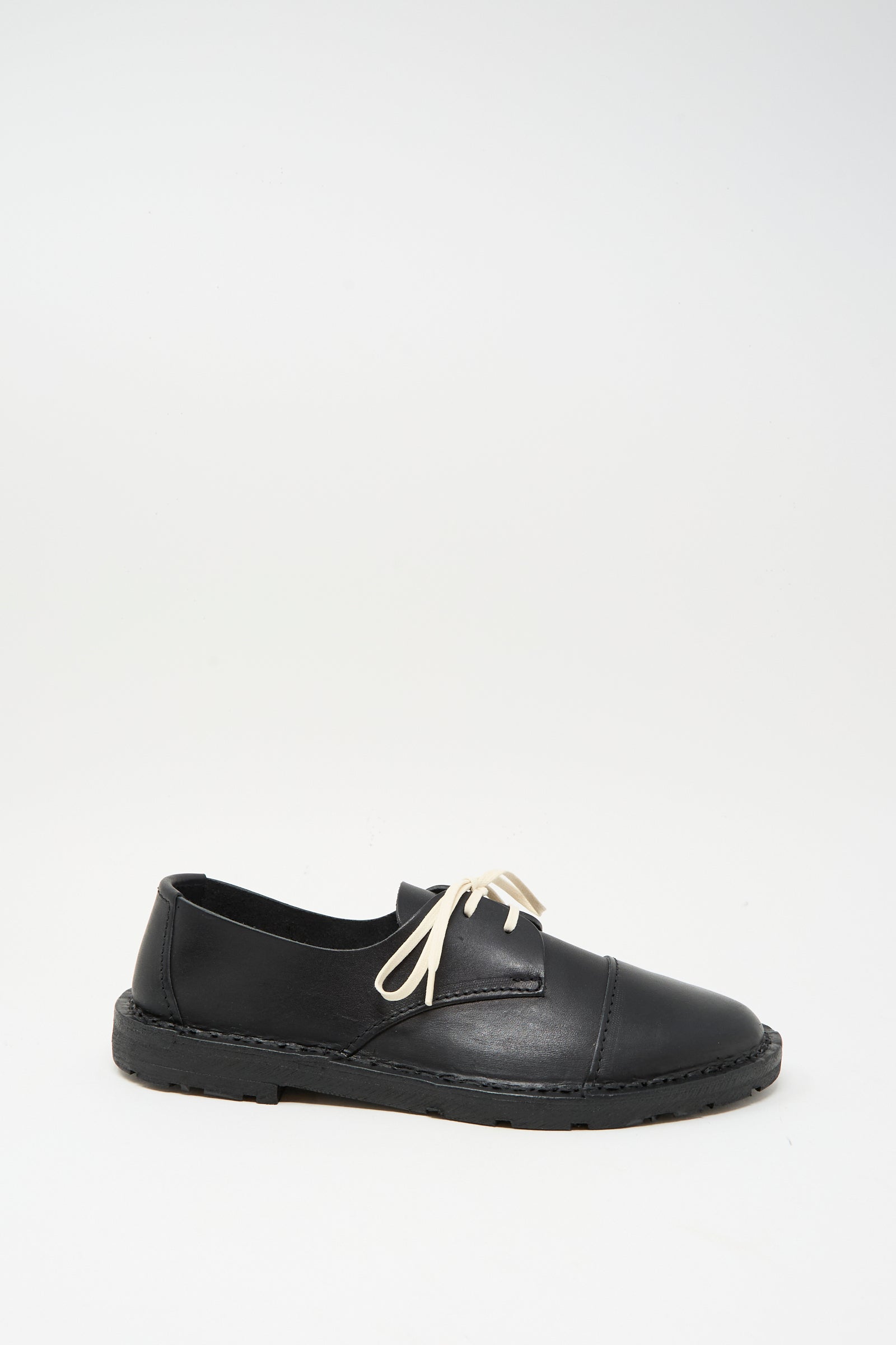 The Steve Mono Leather Oxford in Black features a rounded toe, low heel, white laces, and vegetable-tanned leather, shown against a plain white background.
