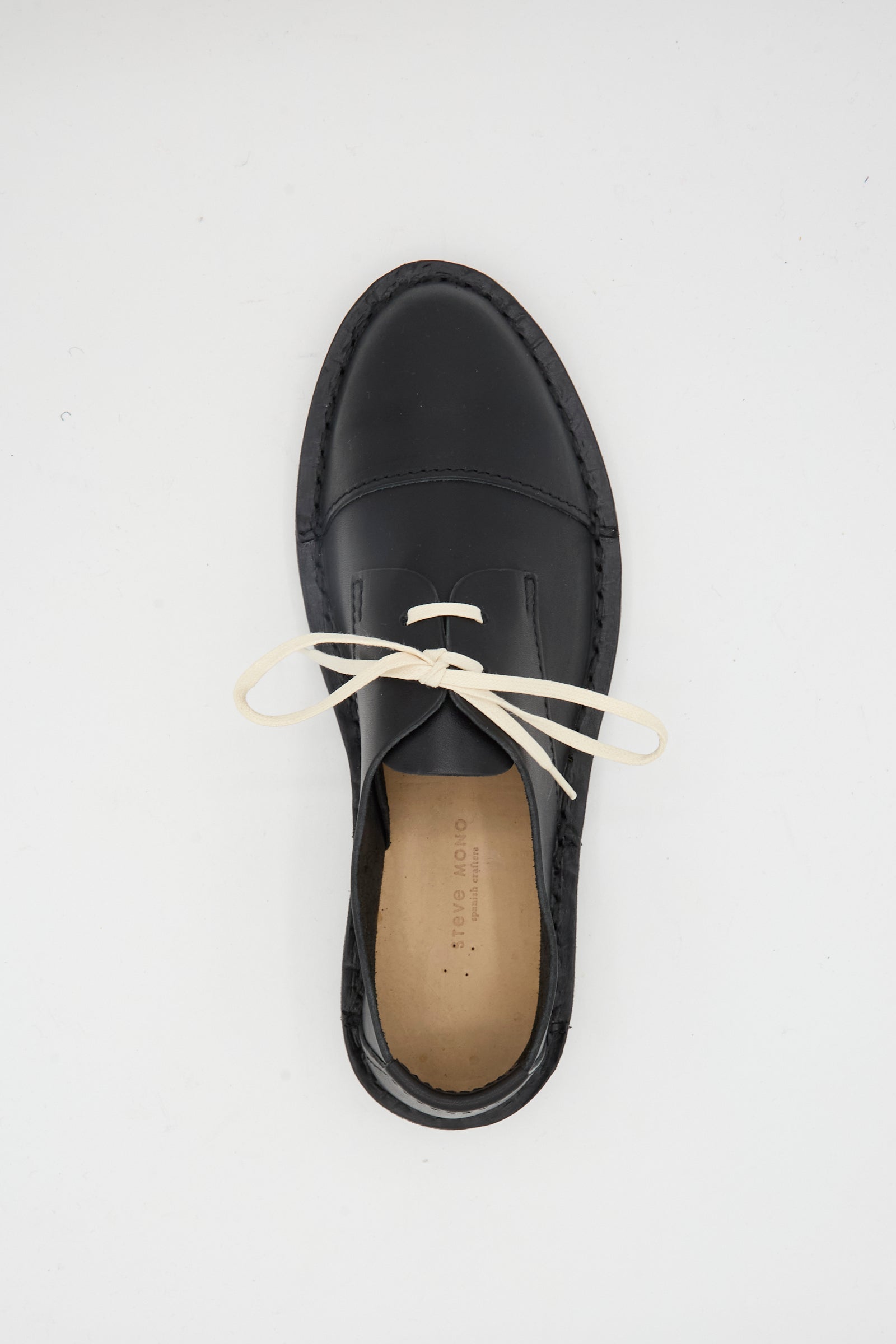 The Steve Mono Leather Oxford in Black, made from vegetable-tanned leather with white laces, is displayed from above on a plain white background.
