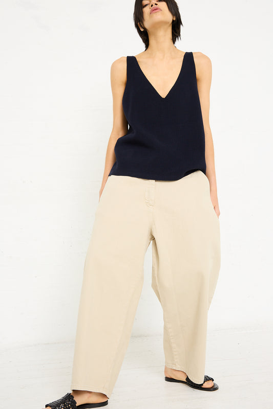 Woman in a sleeveless navy blue top and Denim Chalco Wide Crop Pant in Dove by Studio Nicholson, standing against a plain white background.