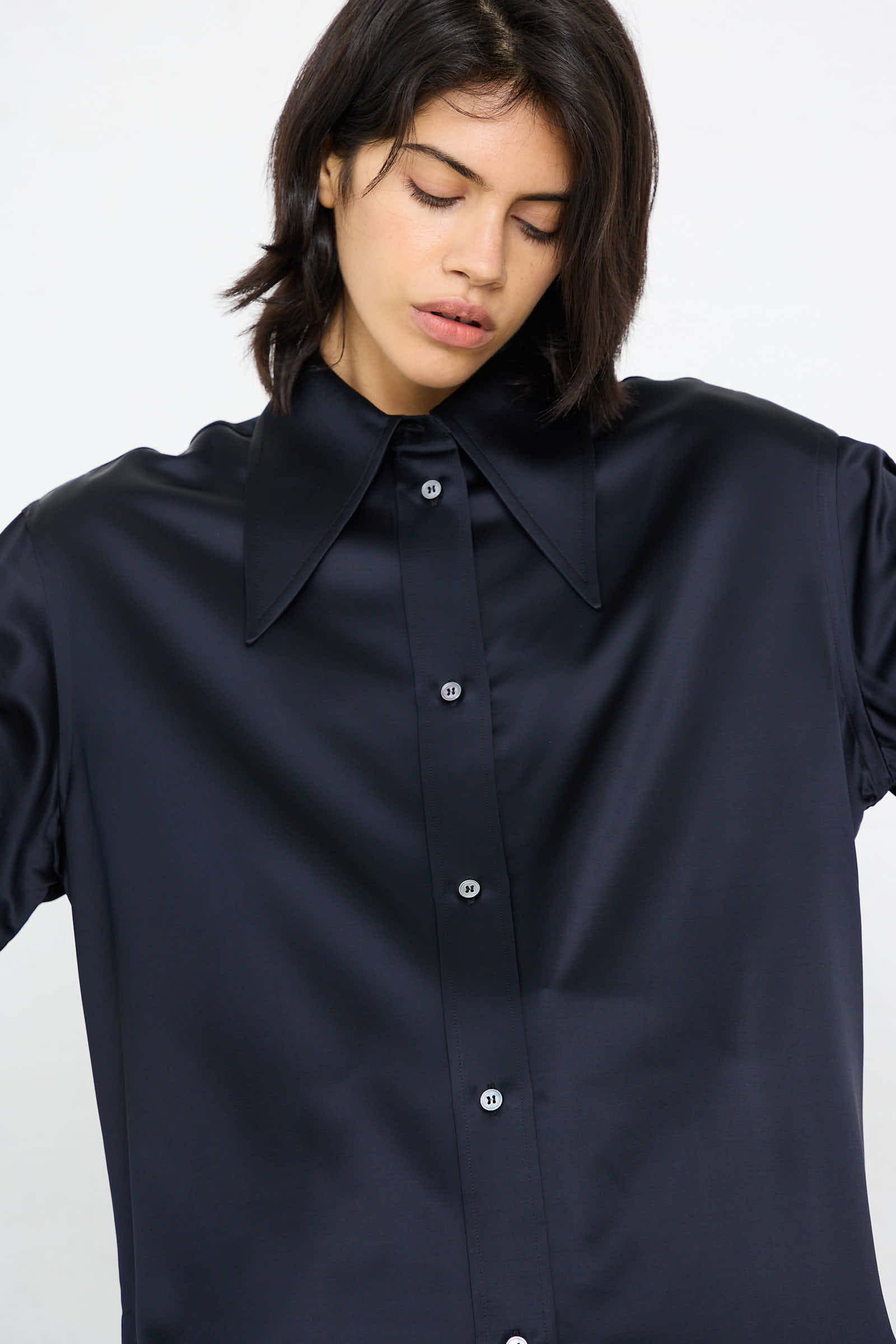 A person with dark hair is wearing the Gable Shirt in Black Ink by Studio Nicholson, standing against a plain background.