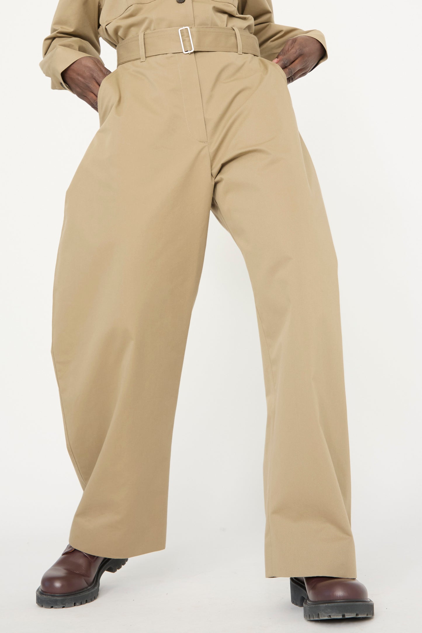 A person wearing Studio Nicholson's Soft Technical Twill Doring Pant in Parcel and brown shoes stands against a plain background.