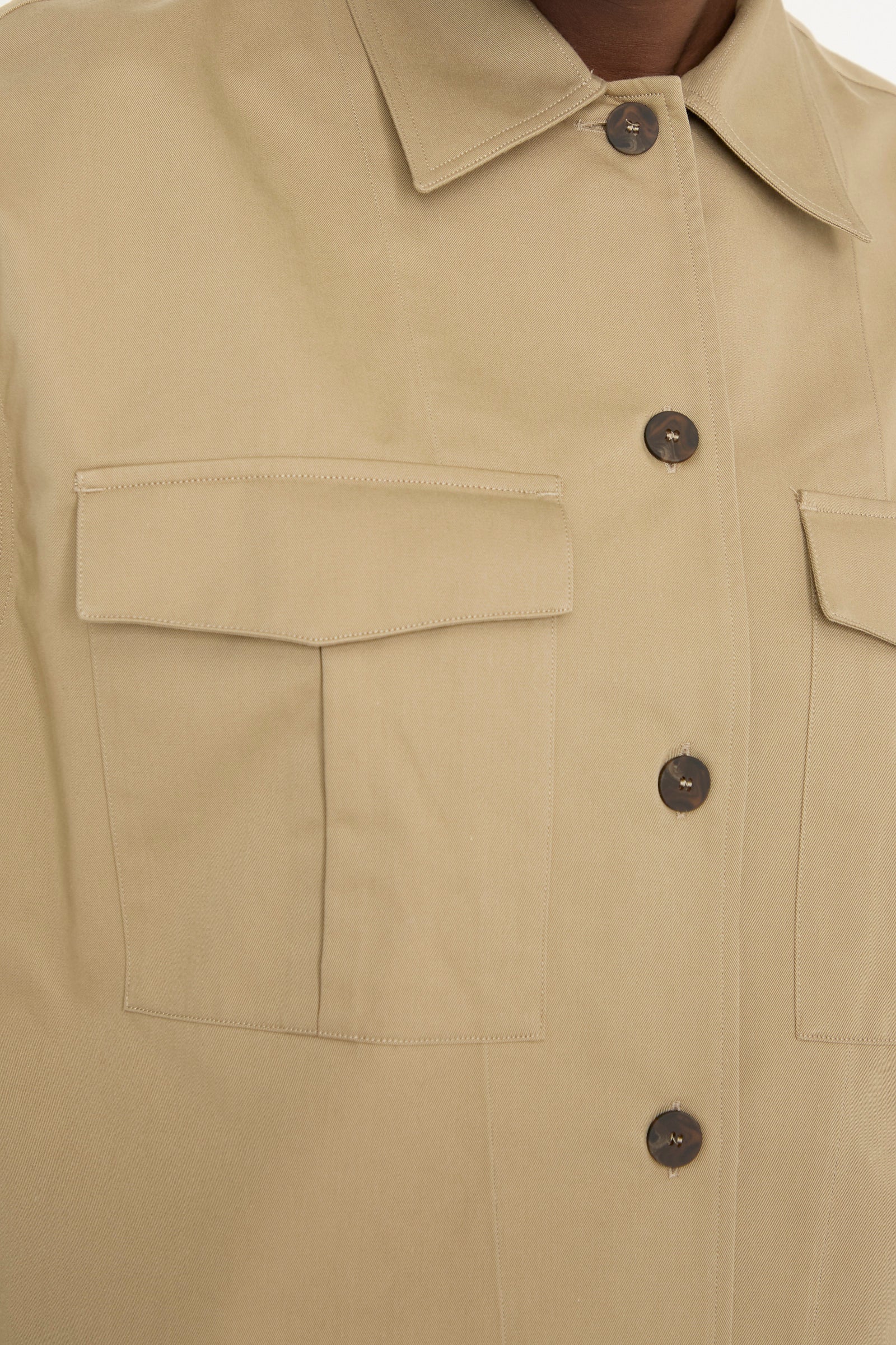 Close-up of the Studio Nicholson Soft Technical Twill Kukes Over Shirt in Parcel, showcasing a beige button-up with a collar and two chest pockets, featuring a boxy fit.