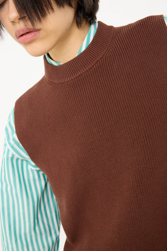 Person wearing a Studio Nicholson brown sweater over a Sumire Sleeveless Top in Carob Brown.