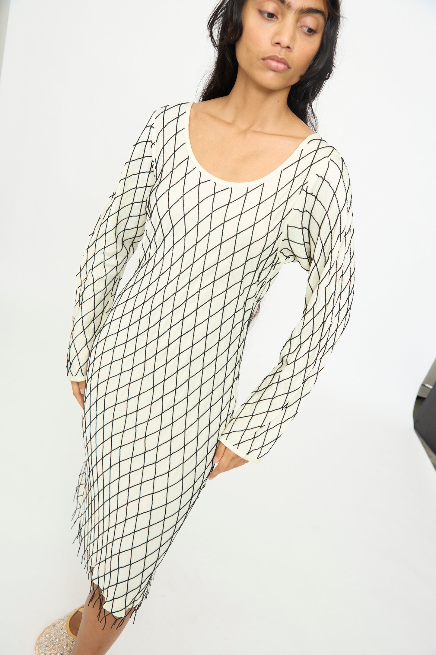 A woman wearing the TIGRA TIGRA Off the Shoulder Dress in pale yellow with black glass beads, standing against a plain white background.