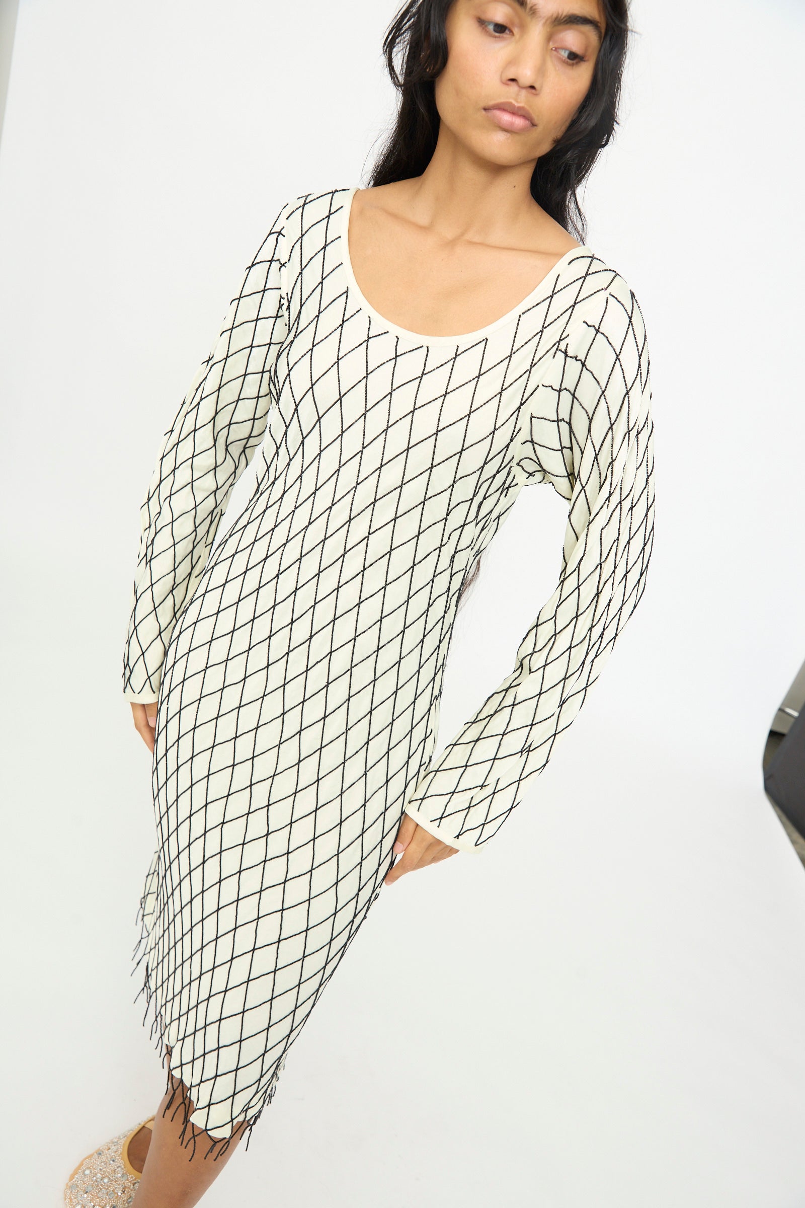 A woman wearing the TIGRA TIGRA Off the Shoulder Dress in pale yellow with black glass beads, standing against a plain white background.