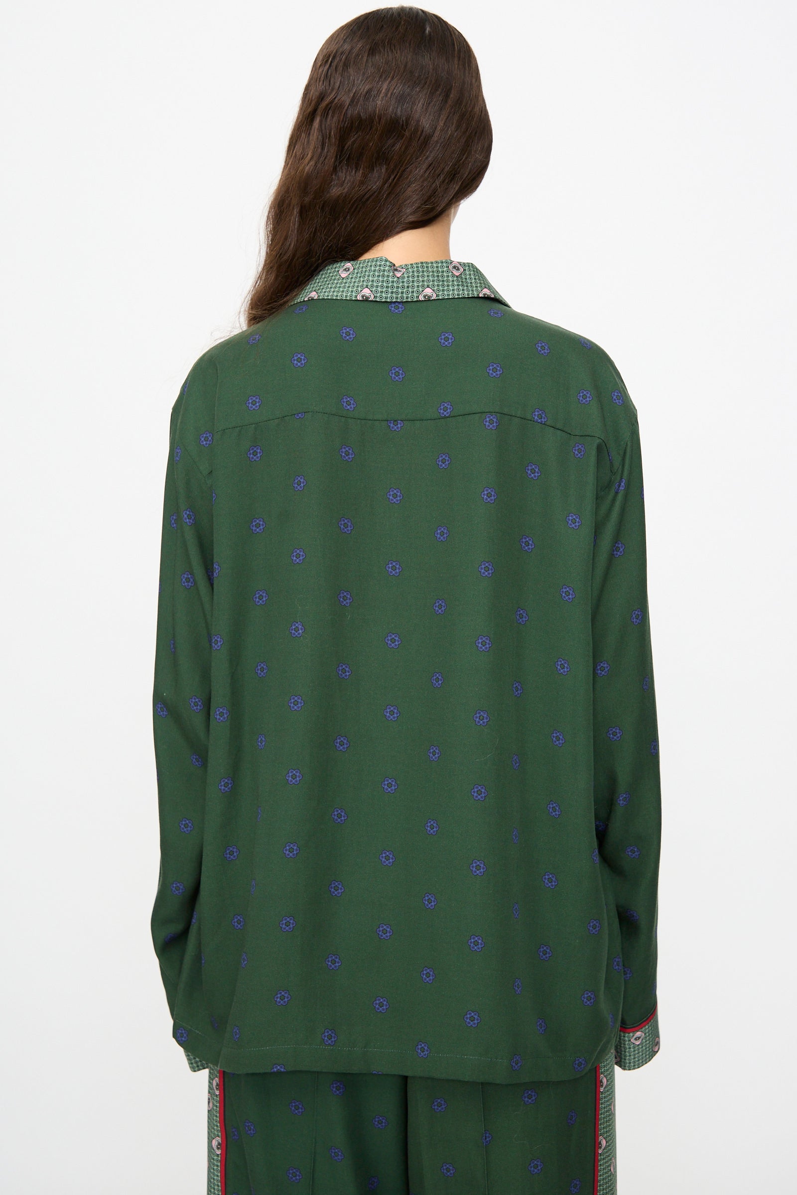 A person with long brown hair, seen from the back against a plain background, wears the TOGA ARCHIVES Inner Print Long Sleeve Shirt in Green—a loose-fitting top featuring blue dots and a plaid collar.