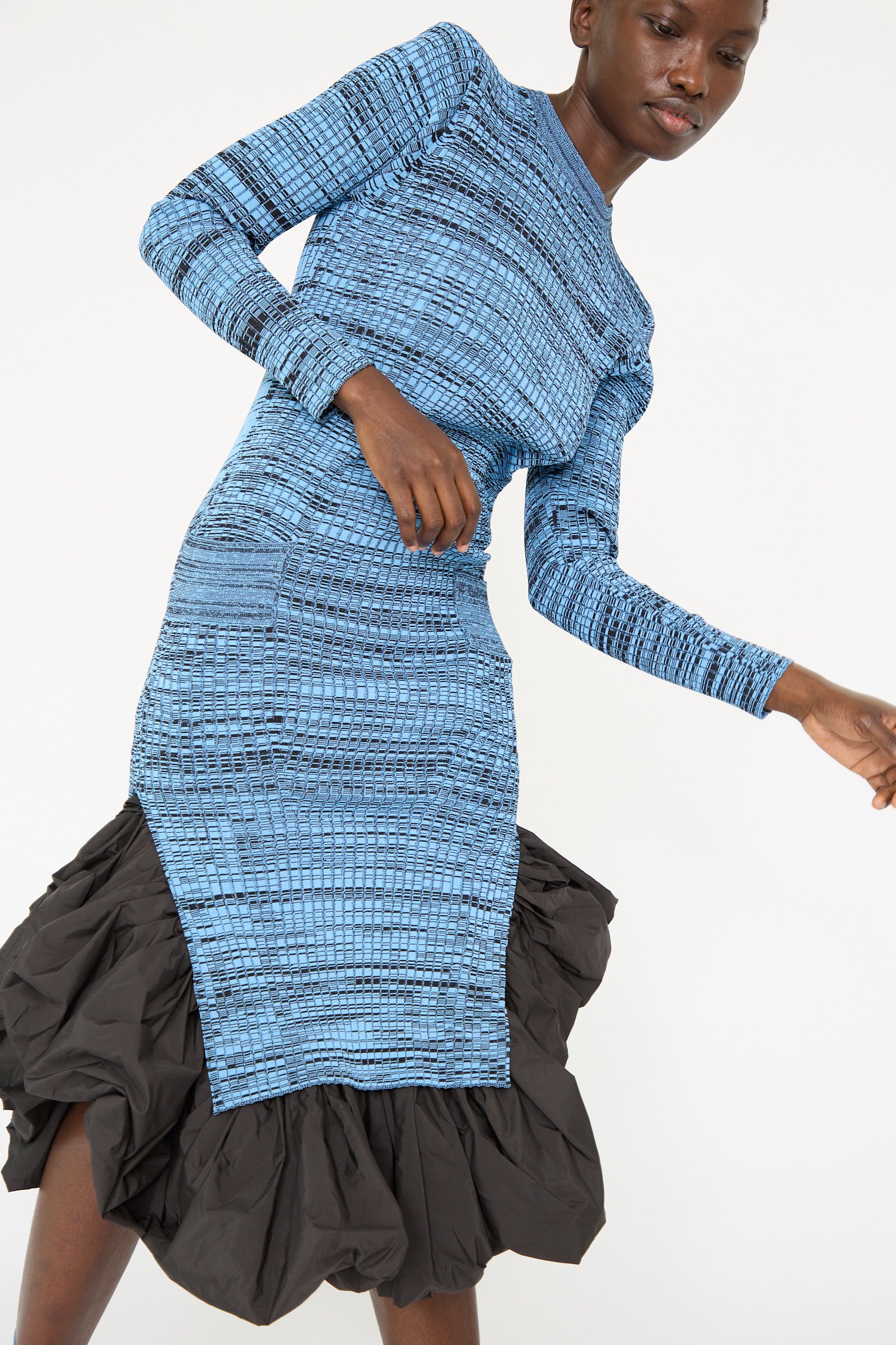 A person is against a plain background, wearing the Wide Rib Knit Dress in Light Blue from TOGA ARCHIVES, against a white background.