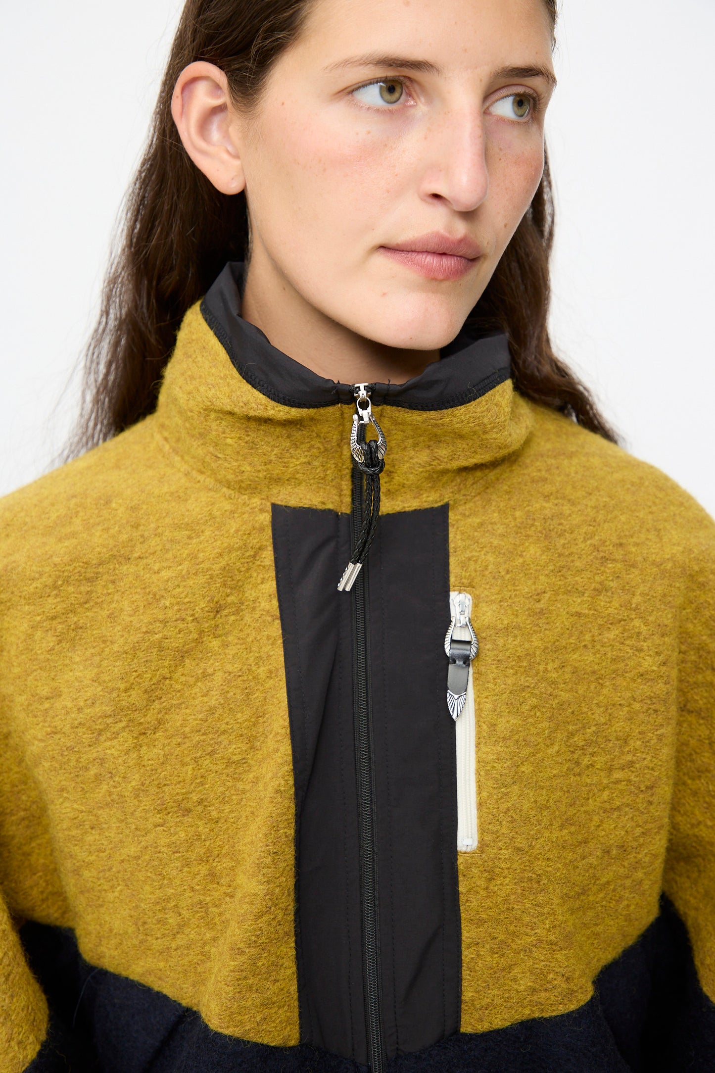 A person wearing the TOGA ARCHIVES Wool Jersey Blouson in navy with a high collar, looking slightly to the side against a plain background.