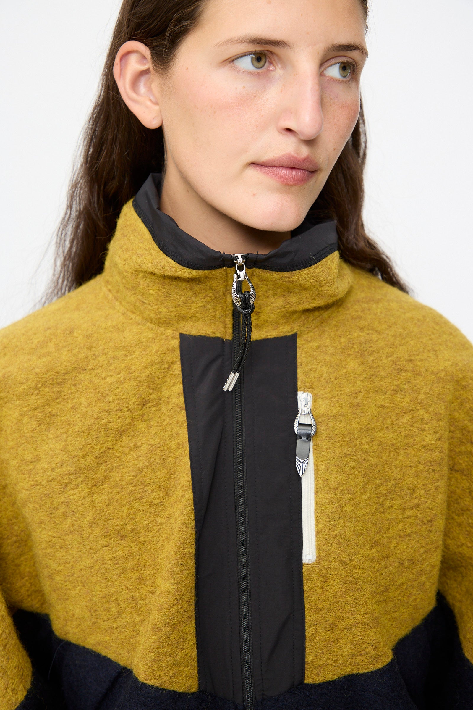 A person wearing the TOGA ARCHIVES Wool Jersey Blouson in navy with a high collar, looking slightly to the side against a plain background.