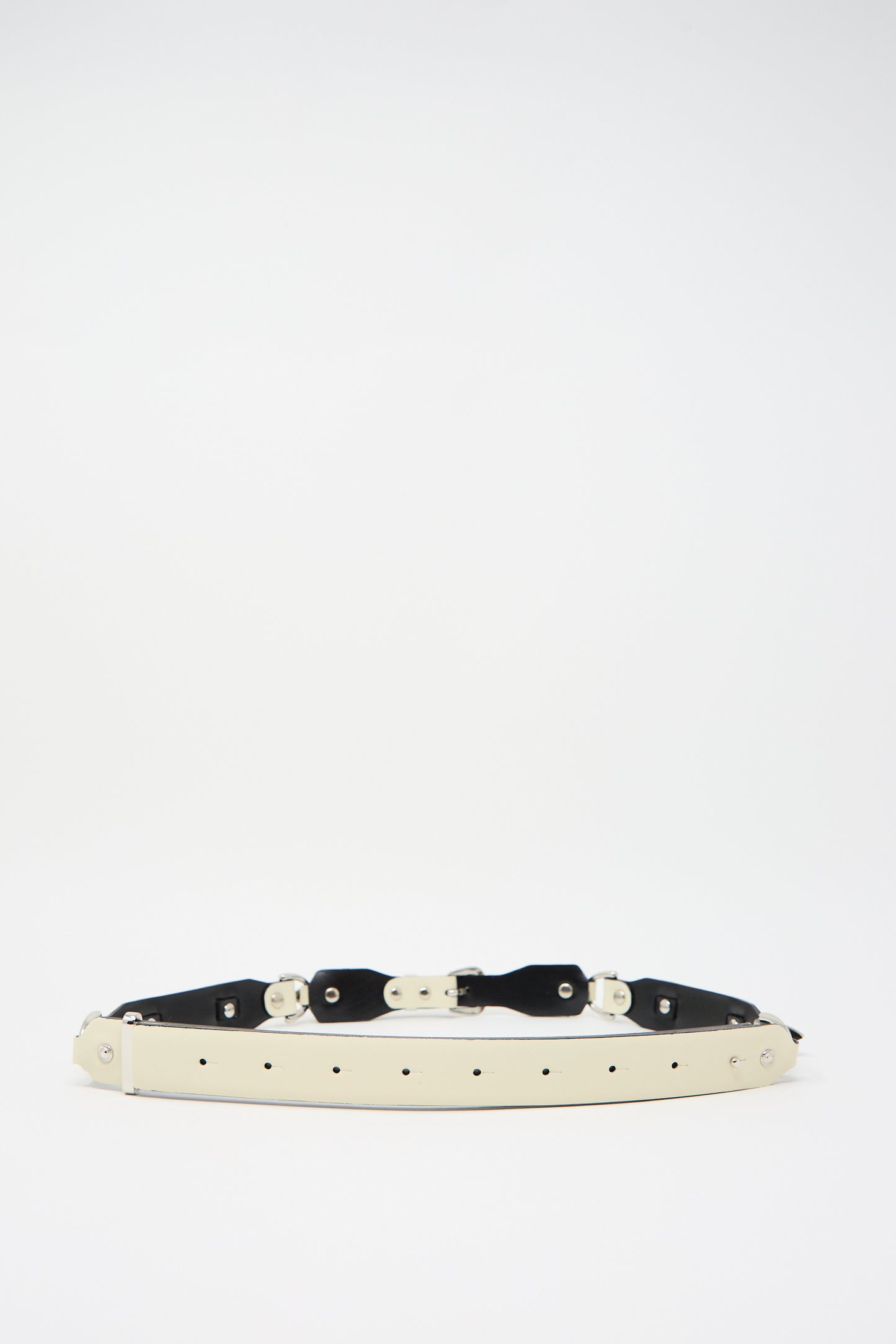 The Metal Leather Narrow Belt in Off White by TOGA ARCHIVES, featuring multiple holes and metal fasteners in a Western-inspired design, lies flat against a plain white background.