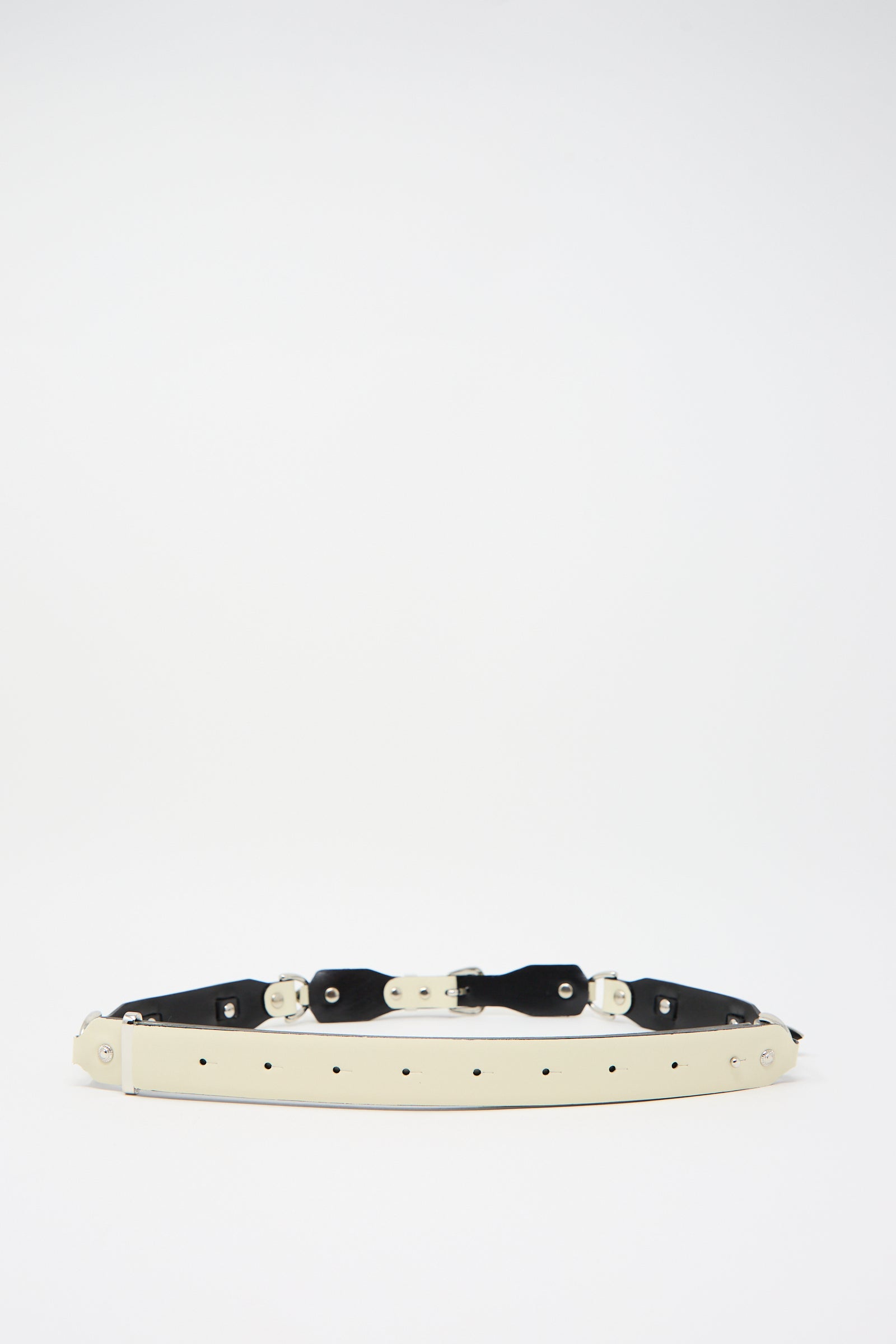 The Metal Leather Narrow Belt in Off White by TOGA ARCHIVES, featuring multiple holes and metal fasteners in a Western-inspired design, lies flat against a plain white background.