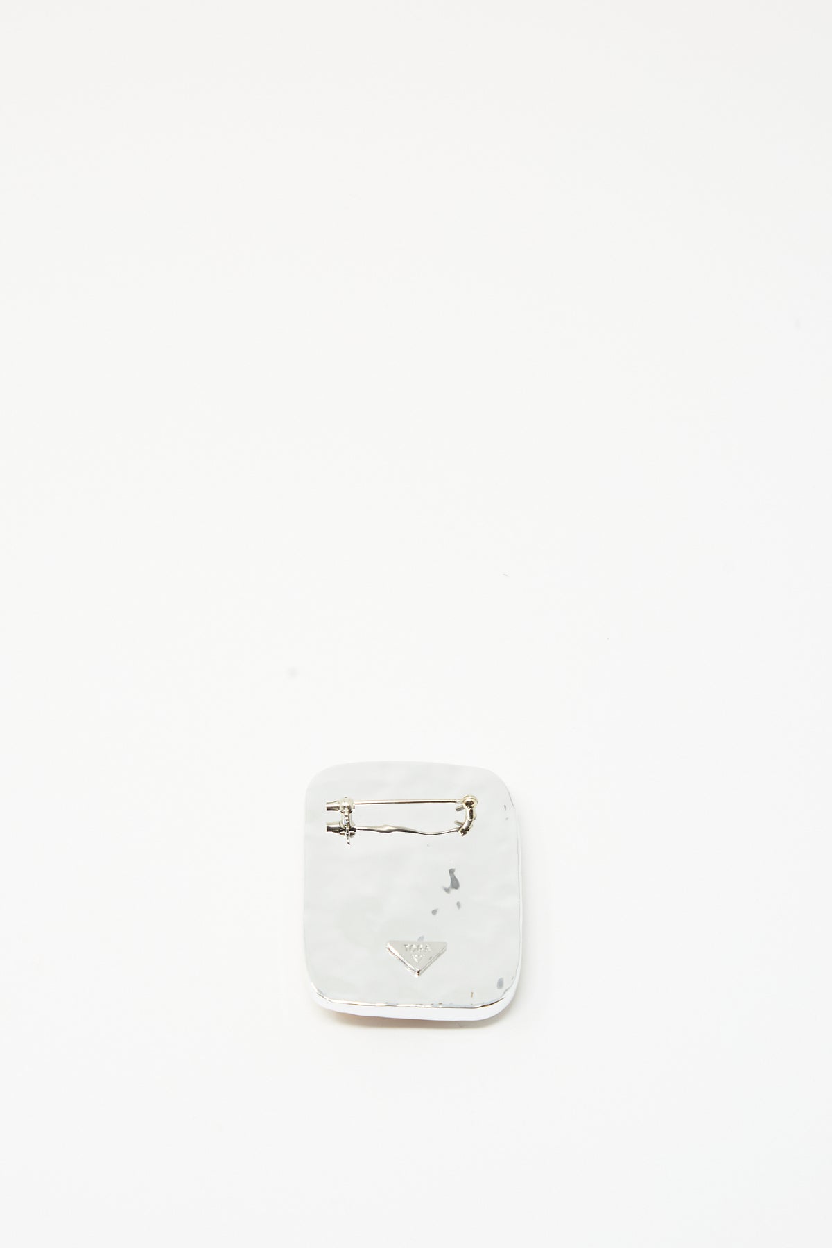 The Square Wave Brooch in Orange by TOGA ARCHIVES, a square silver-tone brass pin with a clasp, is centered against a plain white background.