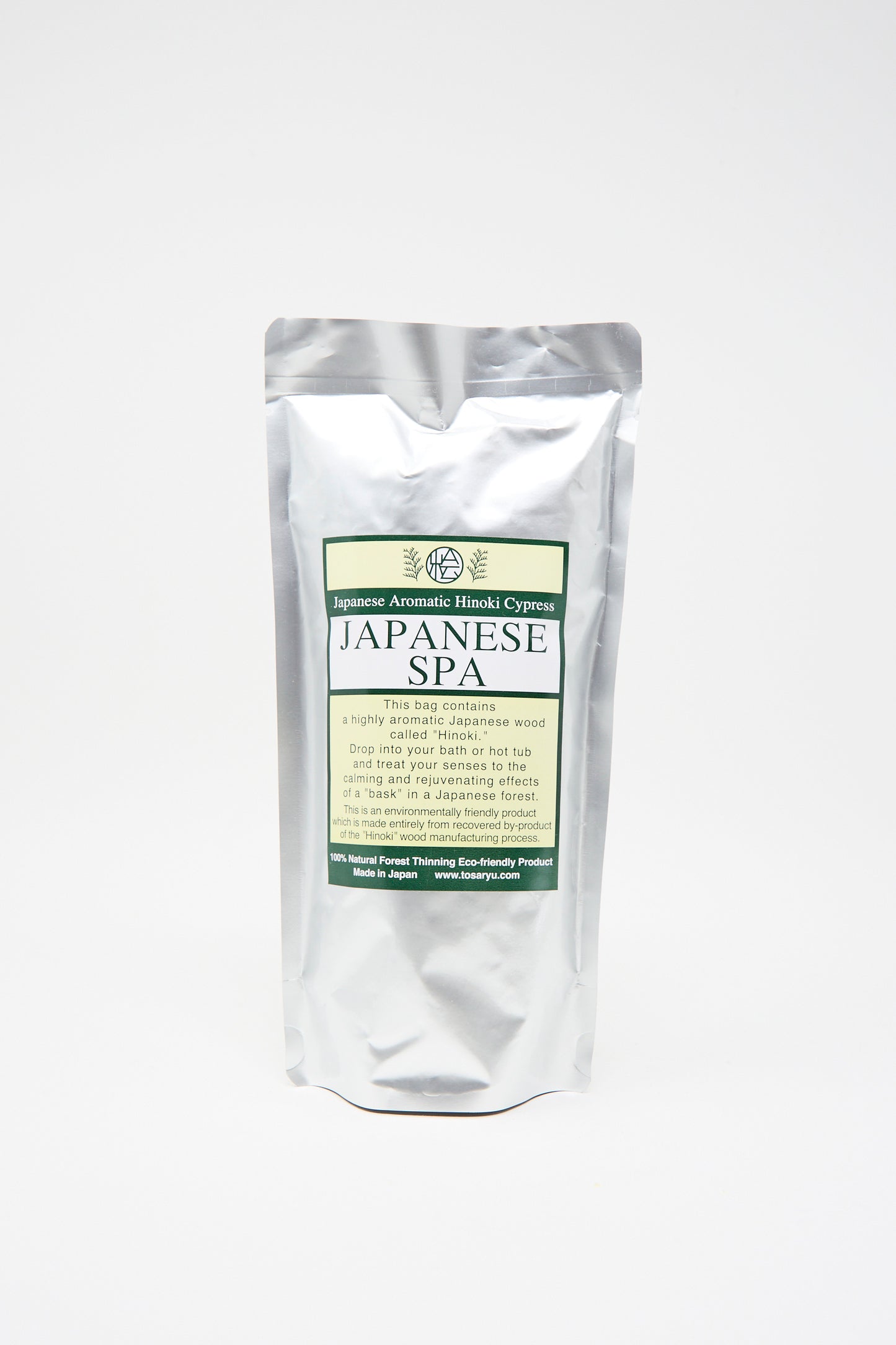 The Hinoki Bath Flakes by Saikai come in a silver pouch labeled "Japanese Spa," offering aromatic hinoki cypress bath flakes, against a white background. 