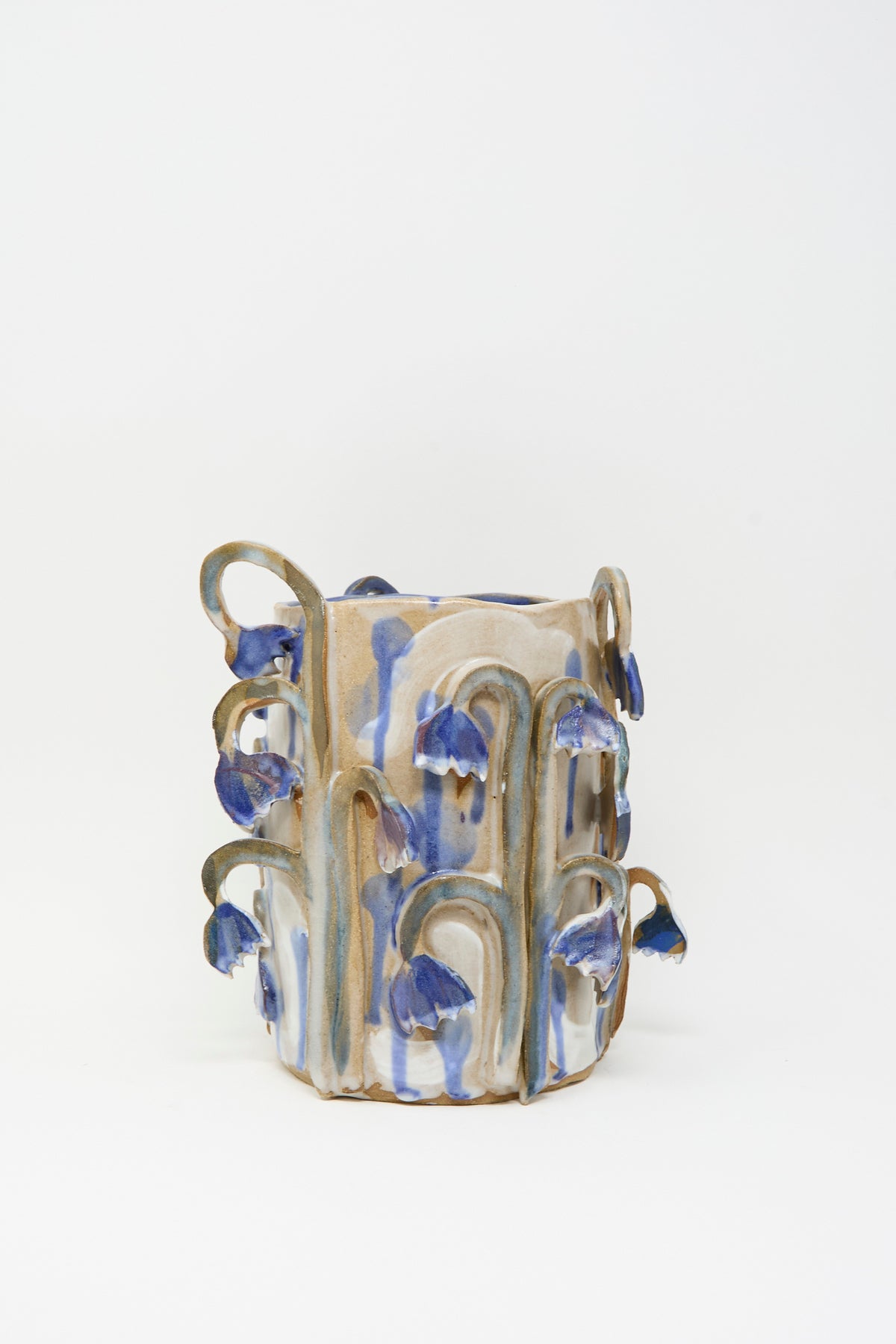 Tamar Mogendorff Bluebell Field Vase, a handmade ceramic piece with a beige surface and applied blue-painted flower embellishments.