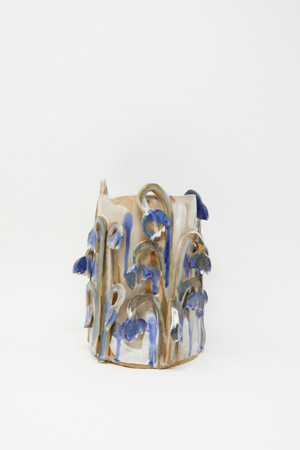 Tamar Mogendorff Bluebell Field Vase, a handmade cylindrical ceramic piece decorated with raised, blue-glazed flower stems.