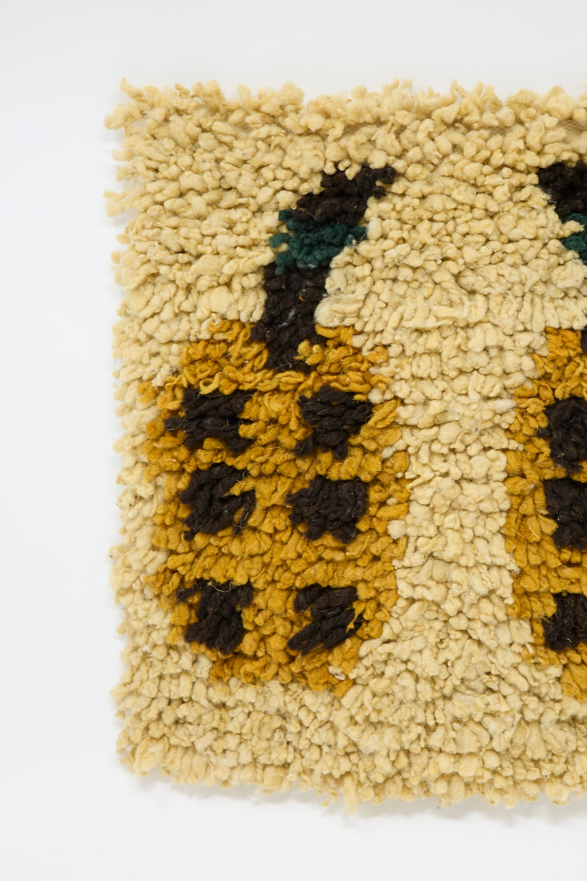 Tamar Mogendorff Chair Rug in Oat: a handwoven wool shag rug with a textured pattern of yellow and brown date motifs on an oat-colored background.