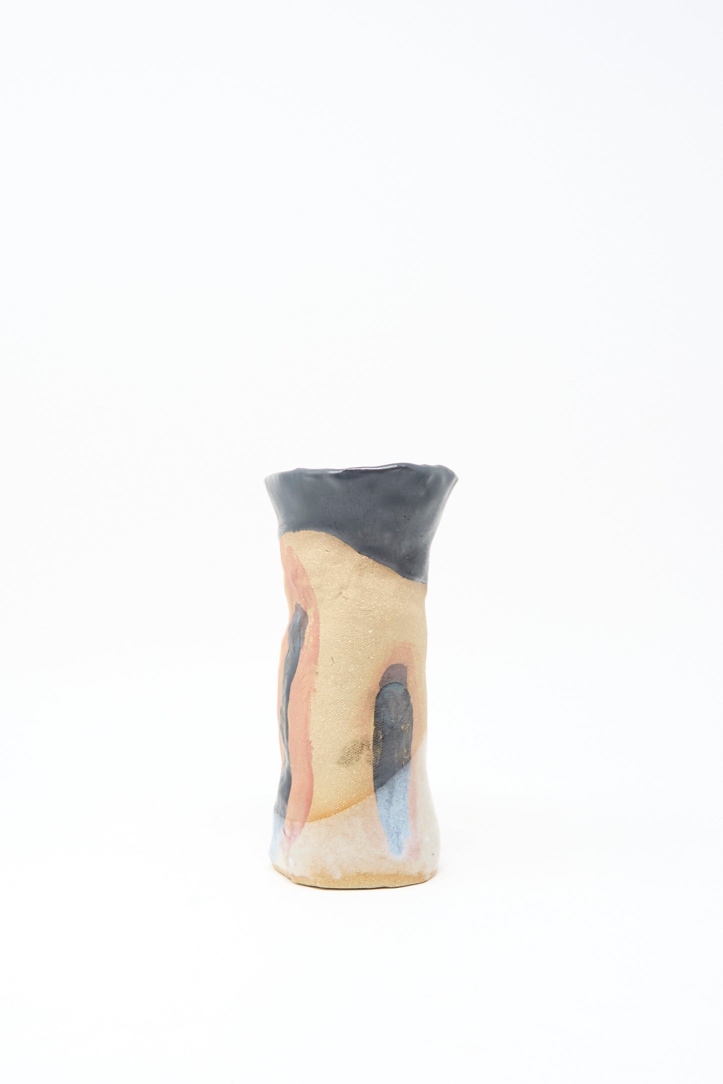 Tamar Mogendorff’s I wish I knew them Candleholder I is a handmade ceramic piece with an irregular shape, beige base, blue and terra cotta abstract patterns, glossy black rim, and subtle black and orange accents, set on a white background.