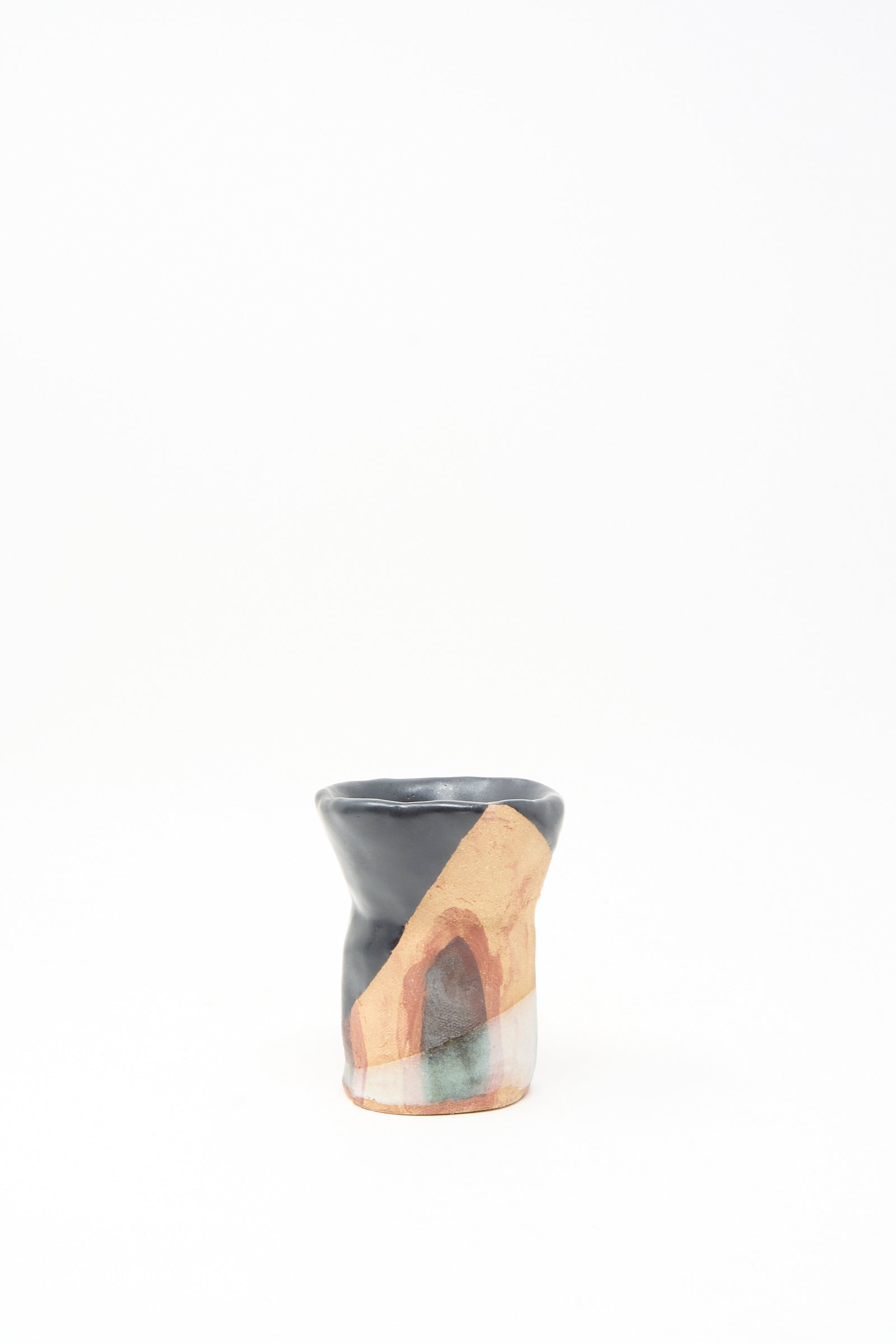 The "I wish I knew them Candleholder II" by Tamar Mogendorff is a small, handmade Brooklyn ceramic piece with abstract earthy patterns and a black rim—an artistic addition to any space.