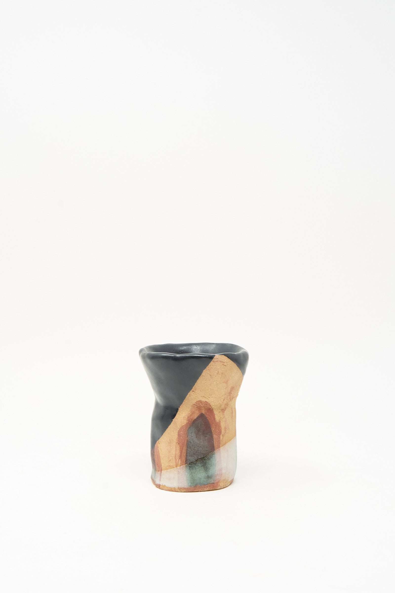 Introducing the "I wish I knew them Candleholder II" by Tamar Mogendorff—a small ceramic vessel crafted in Brooklyn, distinguished by its uneven rim and adorned with black, orange, tan, and reddish abstract patterns. The piece is photographed against a plain white background.