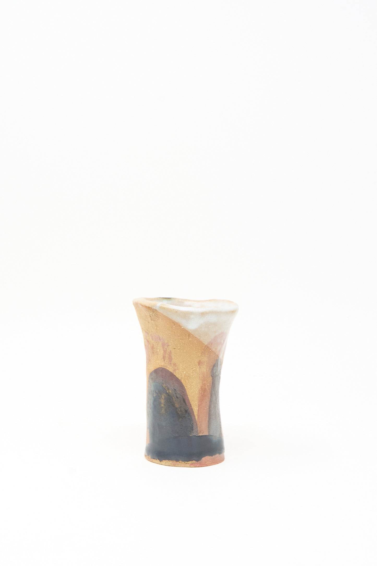 The “I wish I knew them Candleholder III” by Tamar Mogendorff is a small, handmade ceramic candleholder with an uneven rim and earthy brown, tan, and dark gray tones, shown against a plain white background.