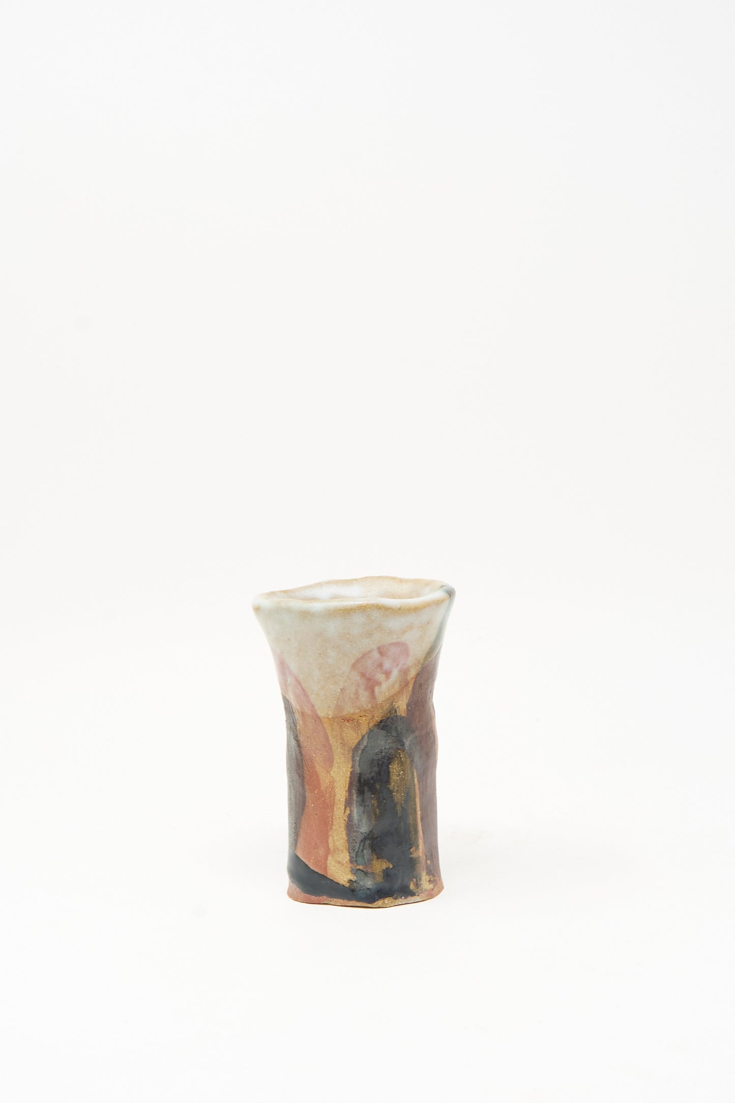 The "I wish I knew them Candleholder III" by Tamar Mogendorff is a small handmade ceramic candleholder from Brooklyn, featuring a flared rim and adorned with abstract multicolored glaze patterns—highlighted by touches of black and orange—set against a plain white background.
