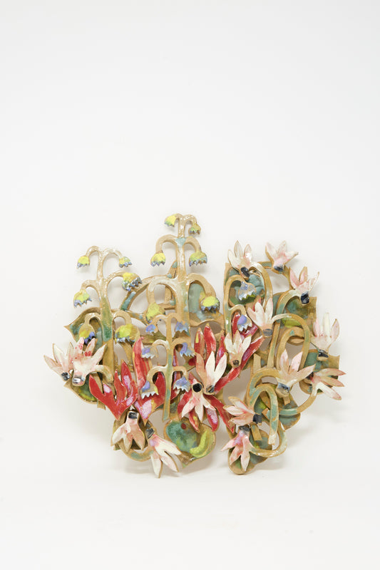 Introducing the "My Garden is on Fire Wall Relief" by Tamar Mogendorff—a stunning decorative ceramic sculpture that serves as striking ceramic wall art. This handmade Brooklyn creation showcases blooming flowers and leafy plants in vivid red, pink, green, and blue hues against a crisp white background. Perfect as a floral wall hanging, each piece beautifully reflects the artistry of Tamar Mogendorff.