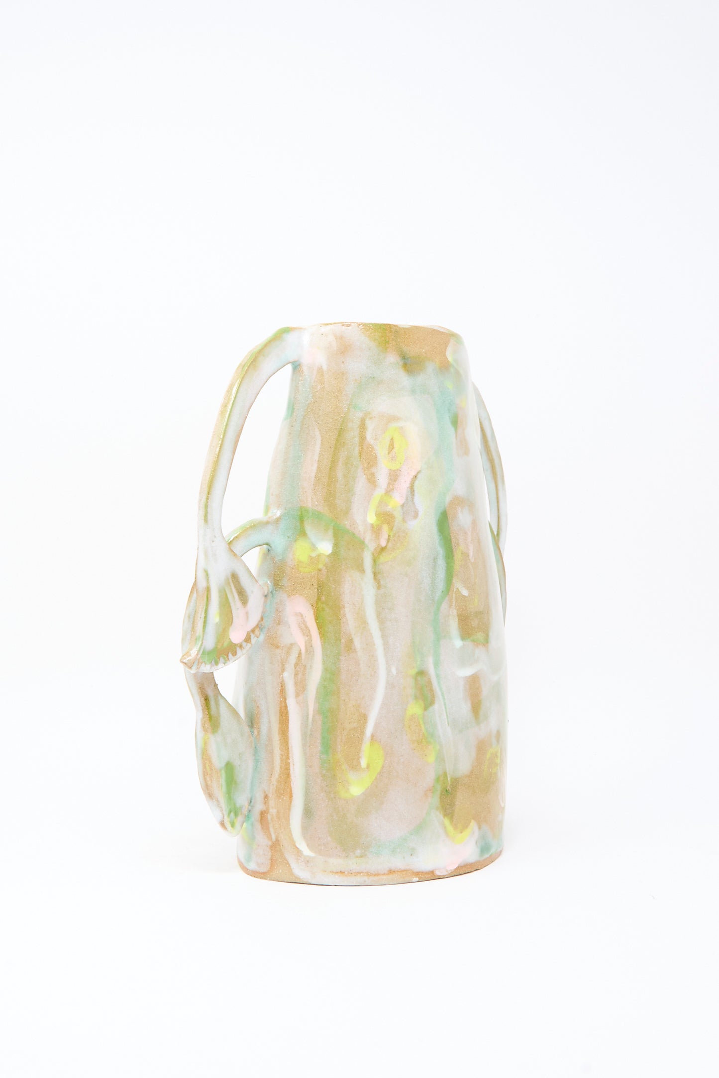The Papyrus Bloom Vase by Tamar Mogendorff is a handmade Brooklyn ceramic piece with glossy abstract pastel glaze in green, yellow, and beige, featuring organic shapes and unique floral handles.