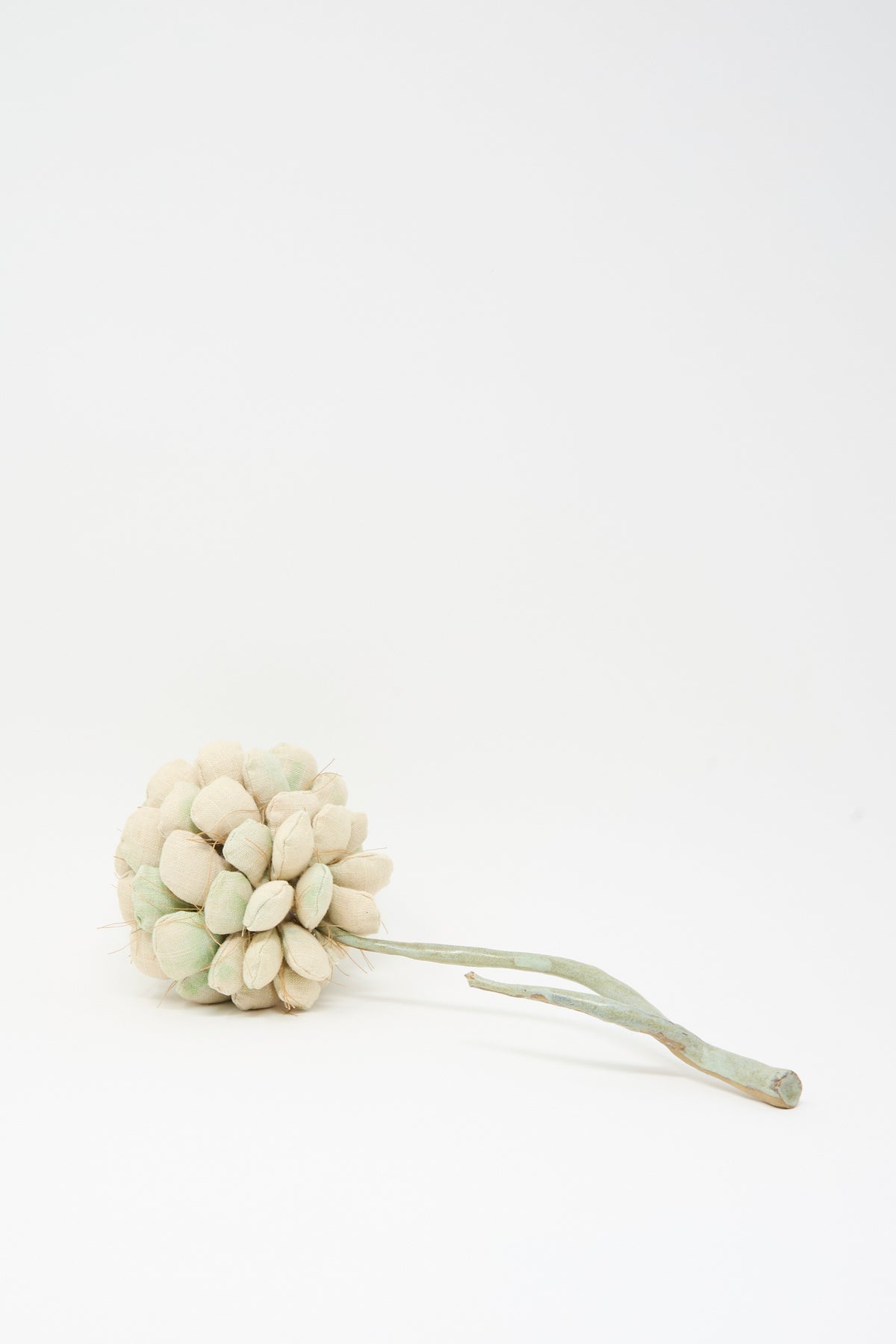 Tamar Mogendorff’s Pine Cone No. 2, a handmade fabric pine cone sculpture with a slender, curved stem set against a white background.